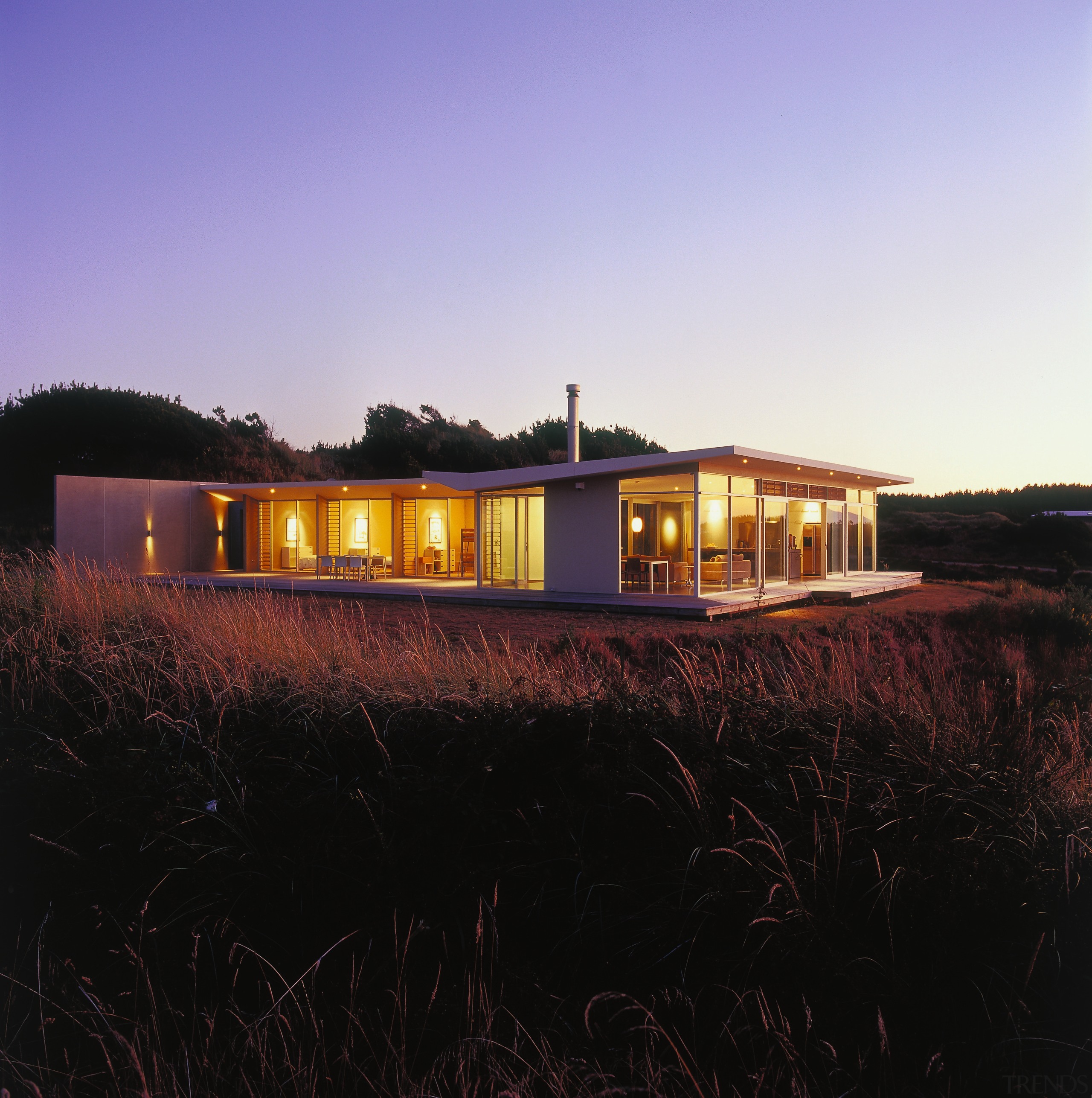 An exterior view of this holiday nestled amongst architecture, cottage, dusk, evening, farmhouse, home, house, landscape, property, real estate, reflection, residential area, sky, sunlight, black