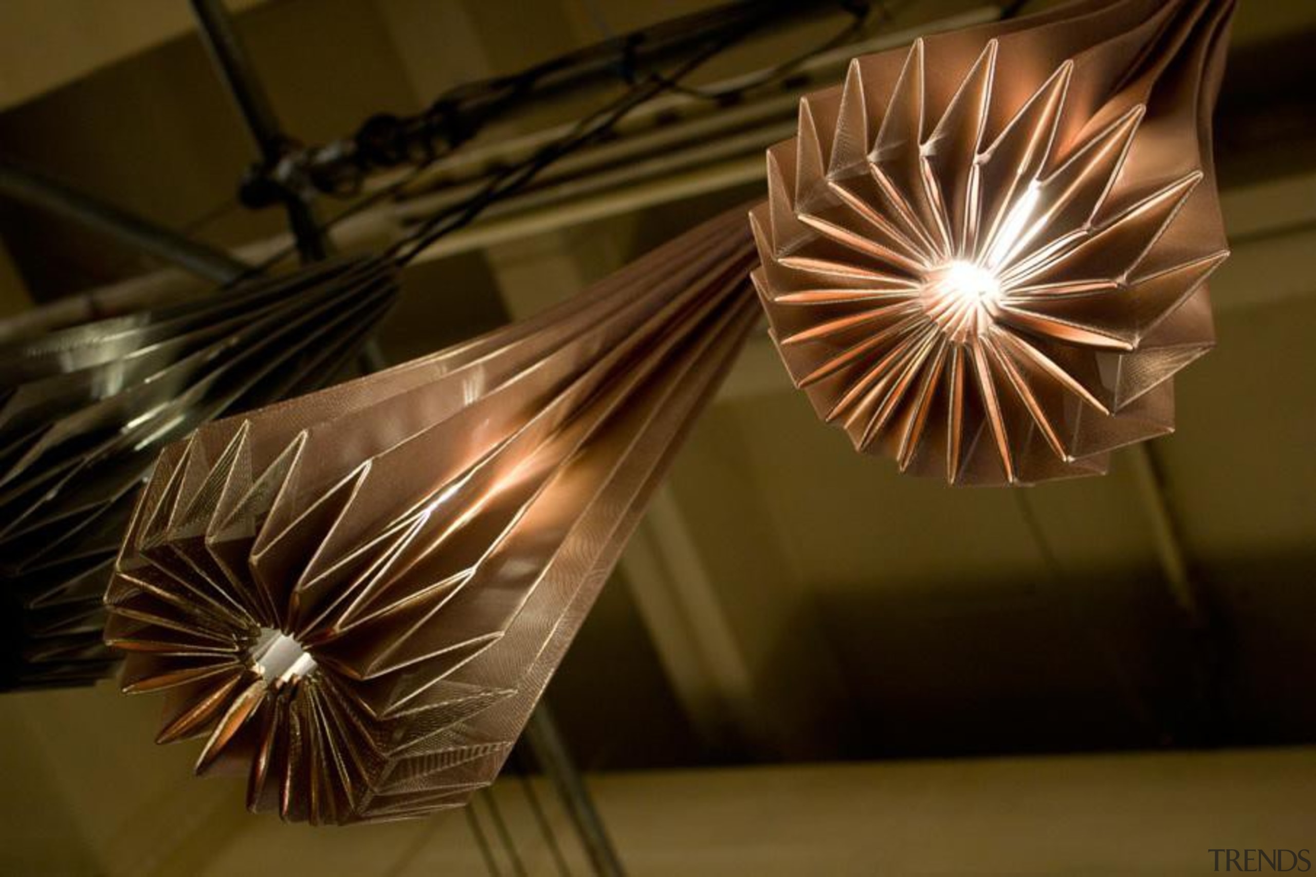 A range of folded metallic fabrics  are light, light fixture, lighting, lighting accessory, wood, brown
