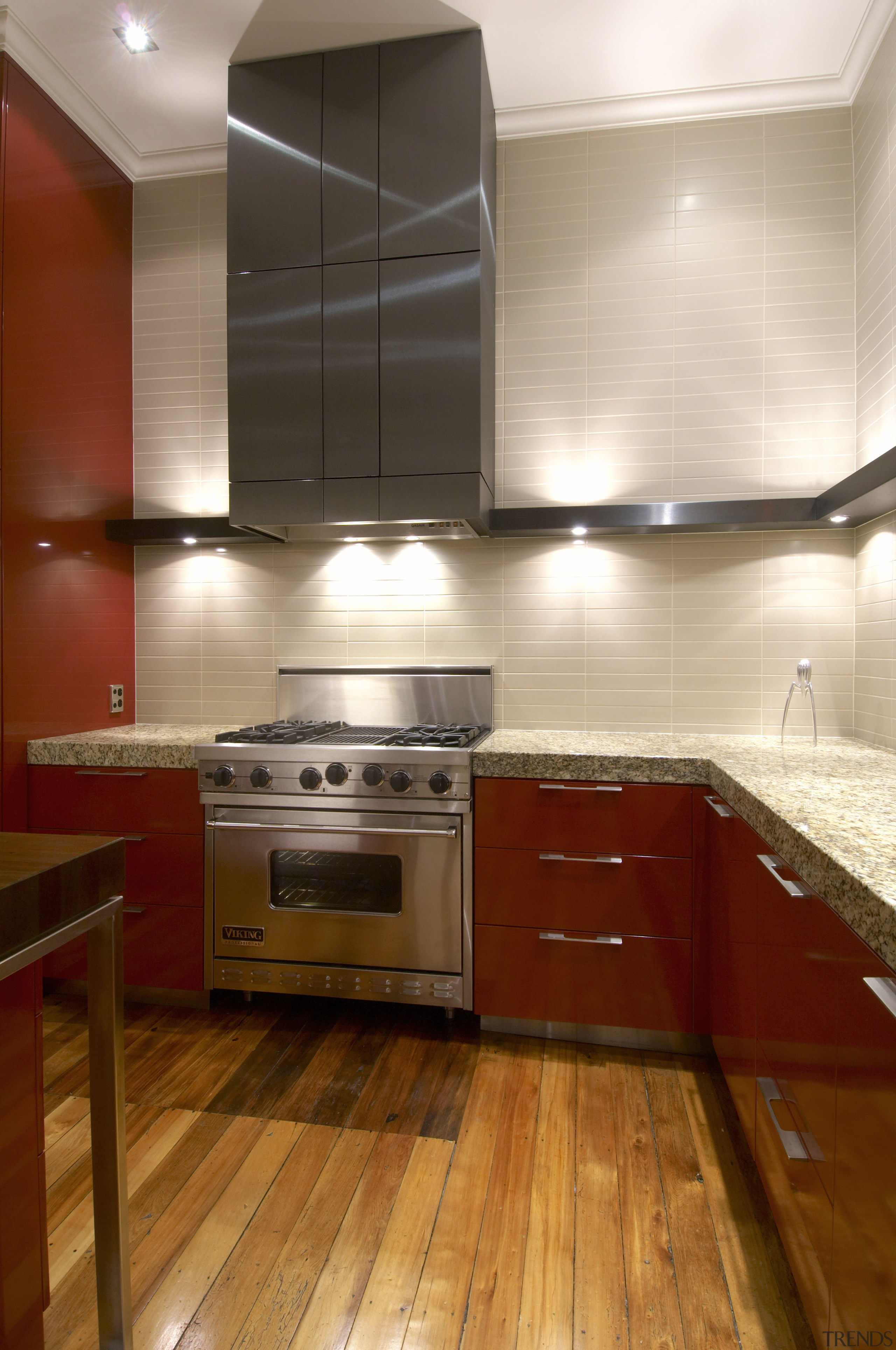 View of oven and cooktop with ventilation overhead, cabinetry, ceiling, countertop, floor, flooring, hardwood, interior design, kitchen, laminate flooring, room, under cabinet lighting, wood, wood flooring, brown