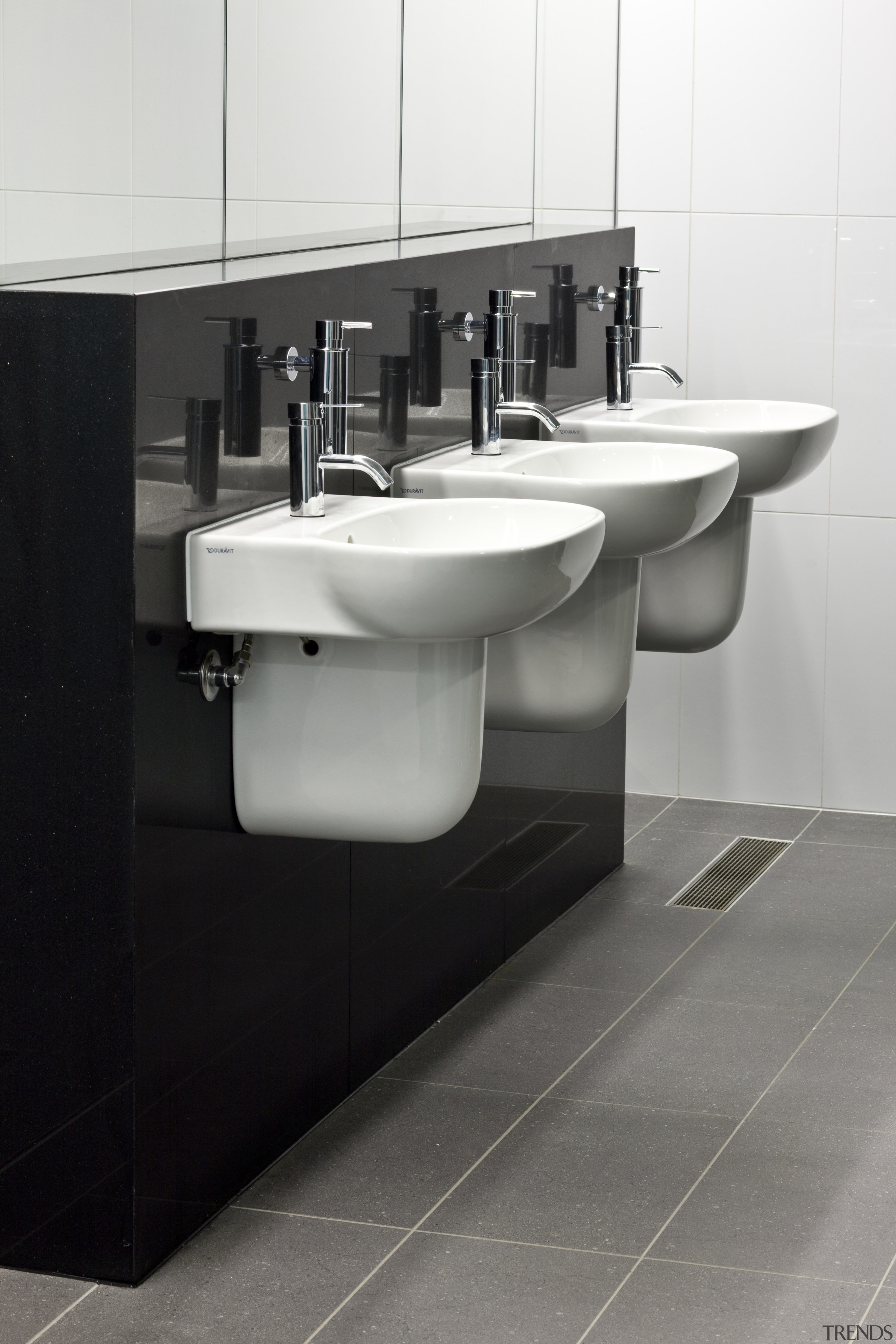 View of bathrooms inside the eco-friendly office building. bathroom, bathroom accessory, bathroom cabinet, bathroom sink, bidet, ceramic, floor, plumbing fixture, product design, sink, tap, tile, toilet seat, white, gray, black