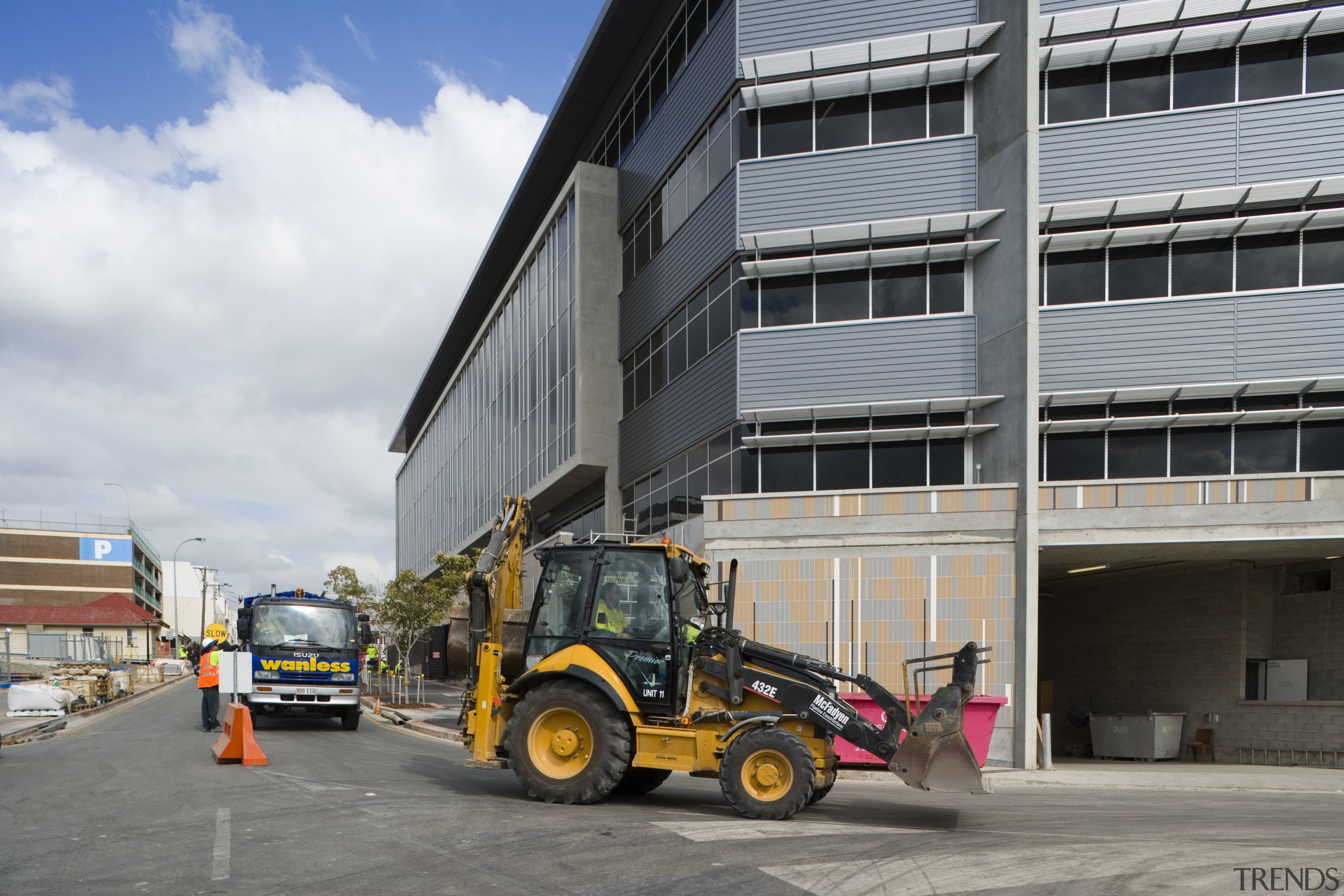 An exterior view of the Greensquare builing and asphalt, car, construction, construction equipment, mode of transport, motor vehicle, transport, vehicle, gray