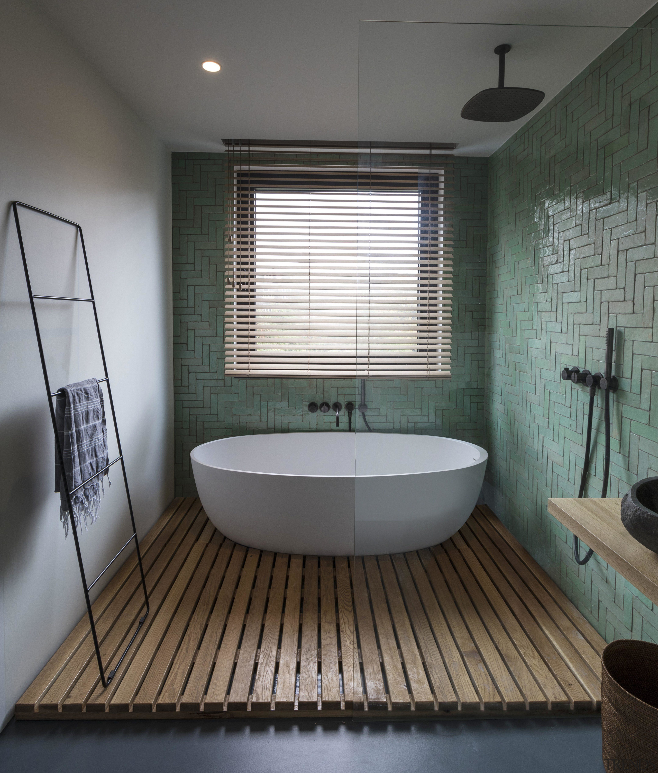 ​​​​​​​This bathroom’s wet area containing the bath tub architecture, bathroom, bathtub, building, ceiling, daylighting, floor, flooring, furniture, hardwood, home, house, interior design, plumbing fixture, property, room, tile, wood flooring, gray, black