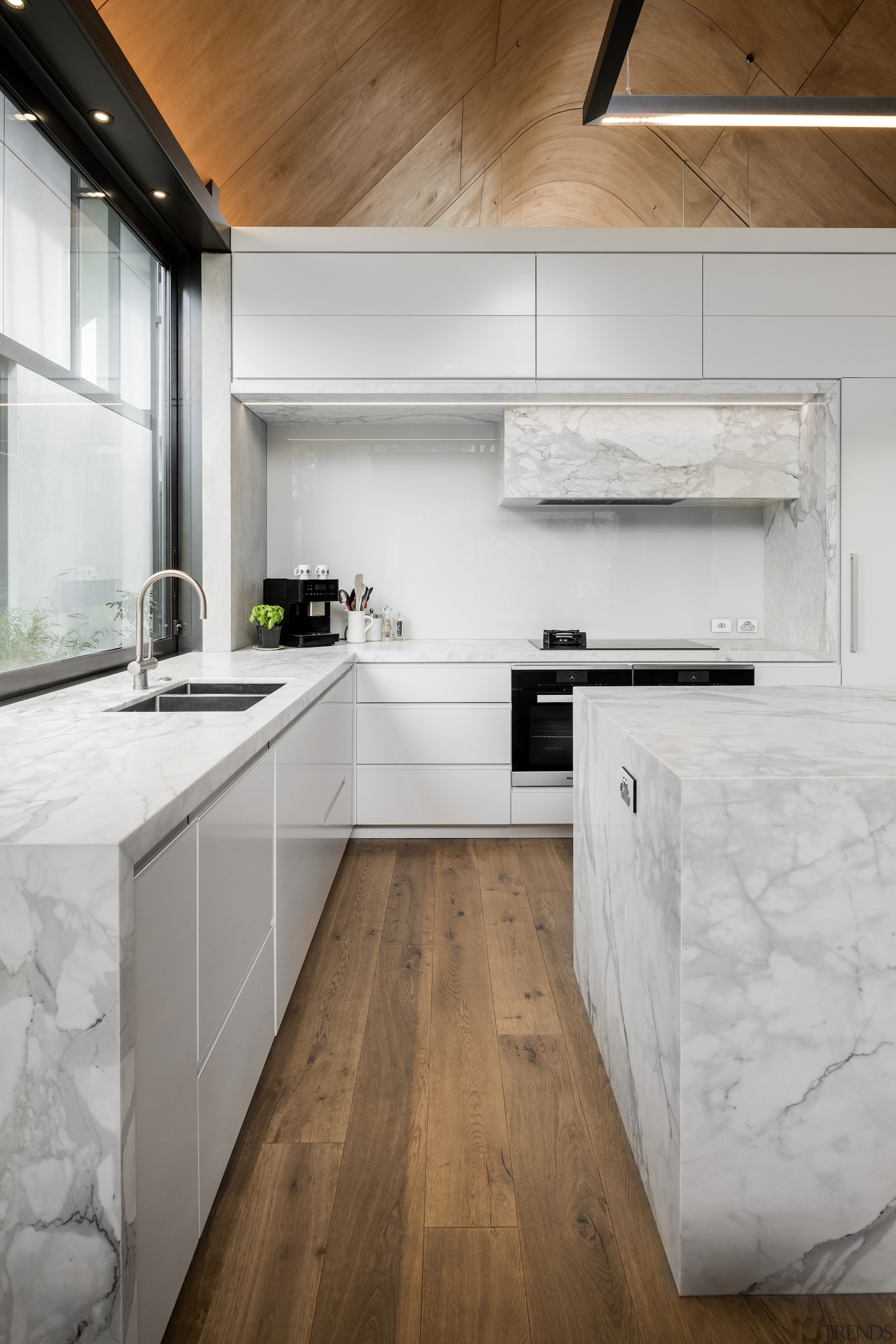 The white and stone-look kitchen contrasts the home's 