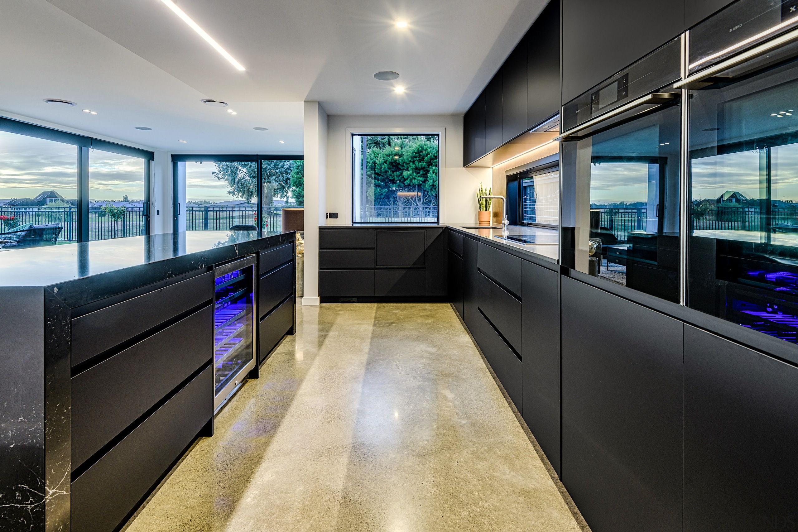 Stained concrete provides a solid anchor for this architecture, building, ceiling, countertop, design, floor, flooring, furniture, glass, home, house, interior design, lighting, office, property, real estate, room, black, gray