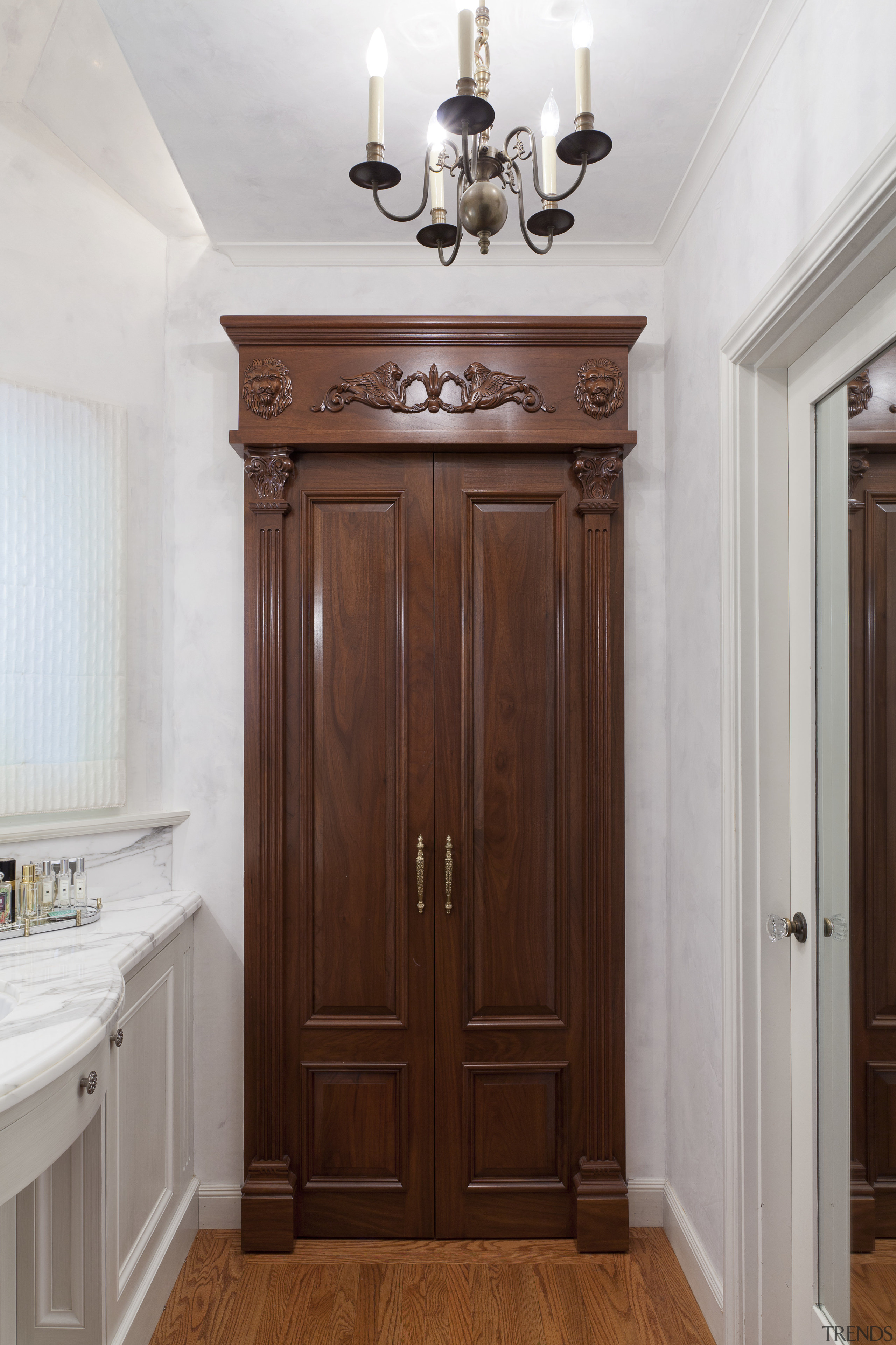 A built-in armoire conceals the entrance to a cabinetry, door, floor, furniture, hardwood, home, interior design, molding, wood, wood stain, gray