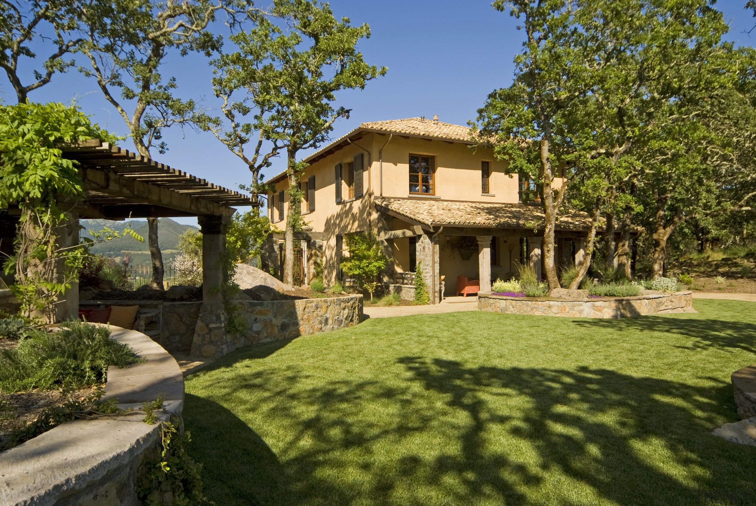 View of the lawn outside this home, features cottage, estate, facade, farmhouse, grass, hacienda, home, house, landscape, mansion, property, real estate, tree, villa, brown