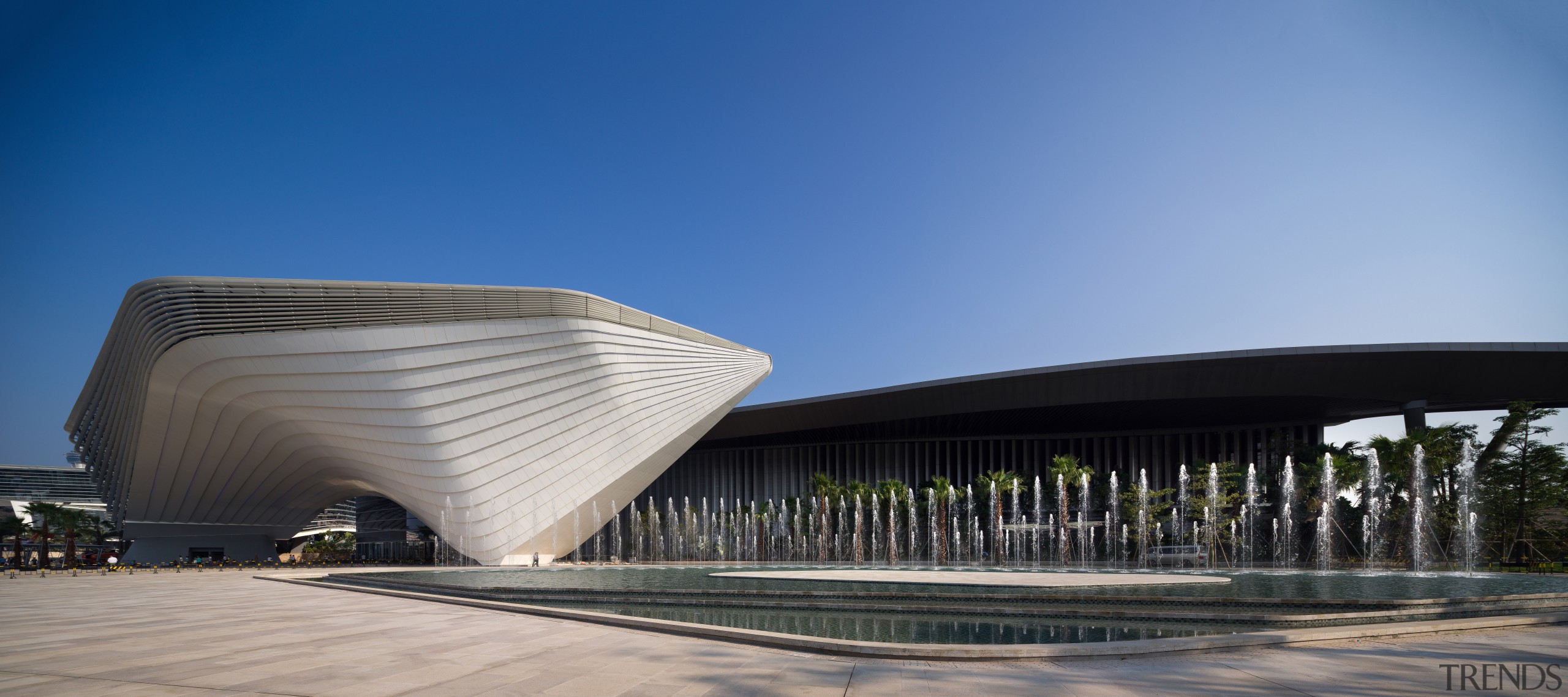 An architectural ribbon winds around the Zhuhai International architecture, building, convention center, corporate headquarters, daytime, facade, fixed link, headquarters, landmark, sky, structure, teal