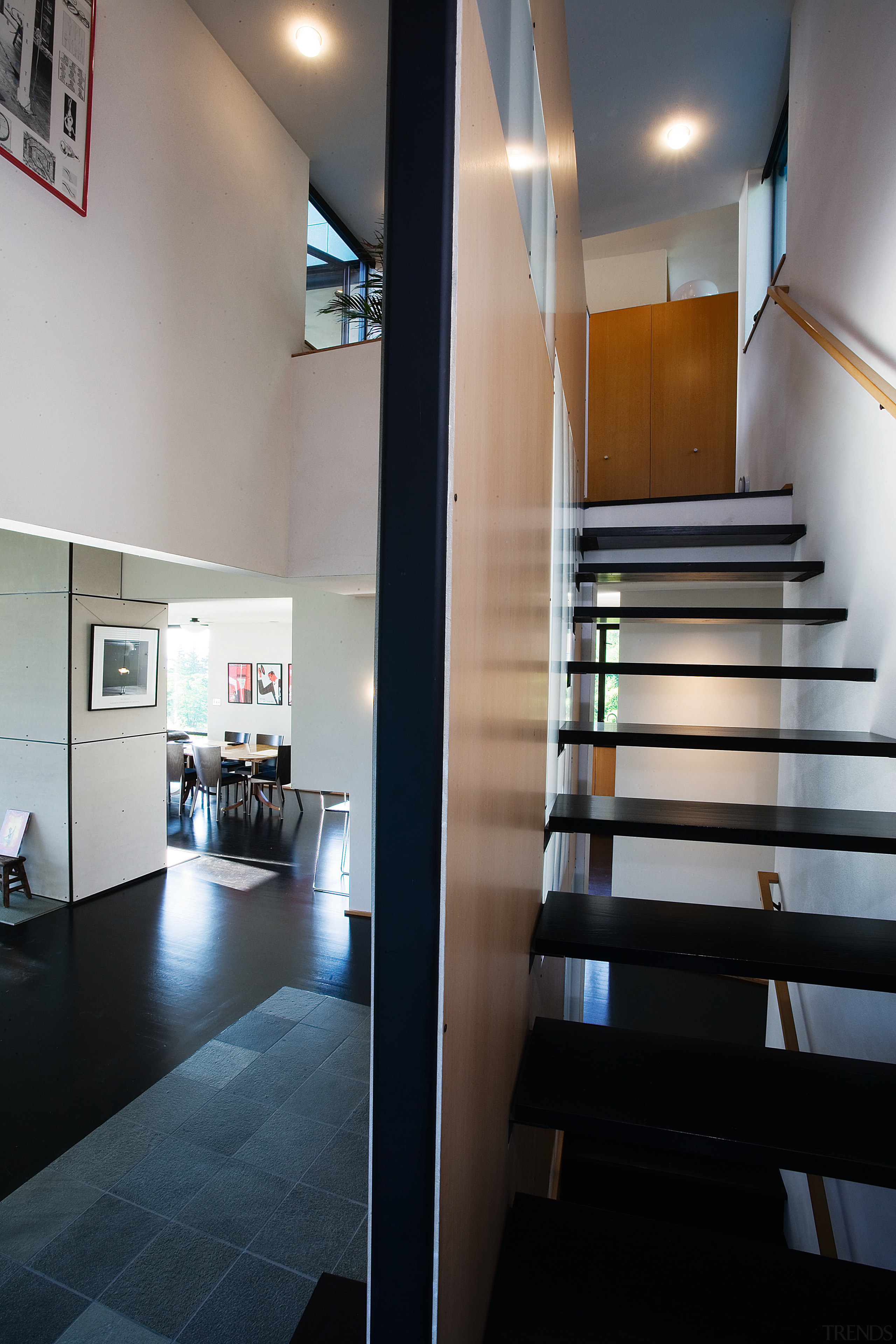 view of the double volume entrance way, feeaturing architecture, ceiling, daylighting, floor, flooring, glass, handrail, house, interior design, stairs, gray, black