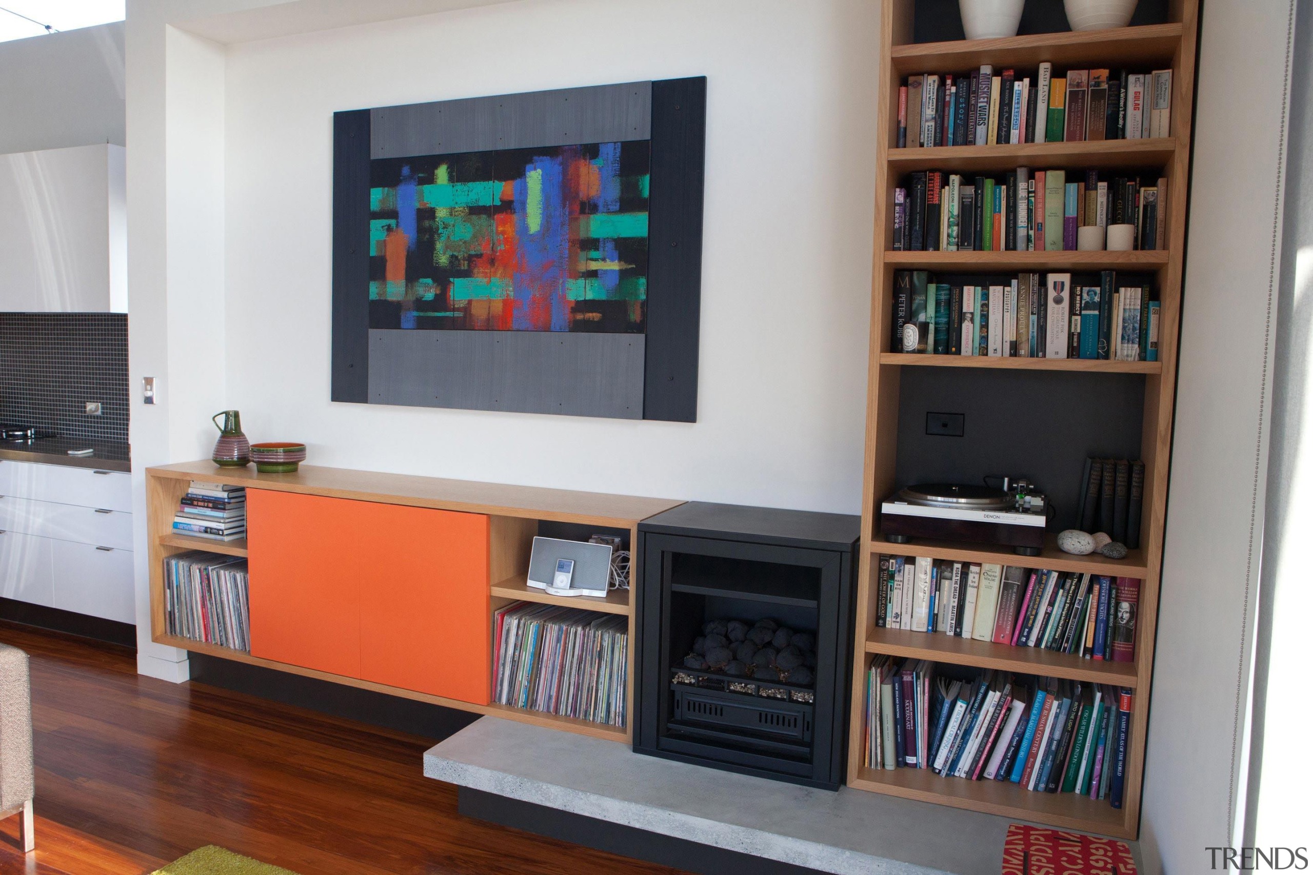 The new gas fireplace integrates seemlessly with the bookcase, furniture, interior design, library, living room, shelf, shelving, gray