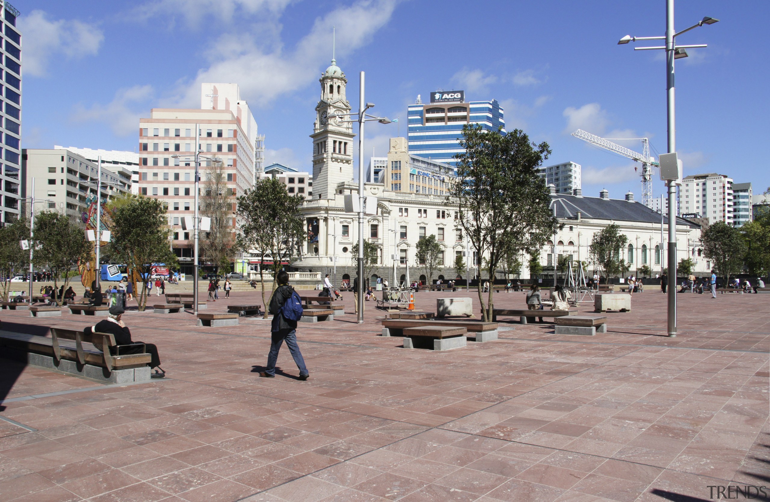 View of Aotea Square which features paving, planters, city, daytime, downtown, metropolis, metropolitan area, mixed use, neighbourhood, outdoor structure, plaza, public space, sky, town, town square, tree, urban area, walkway, gray, teal