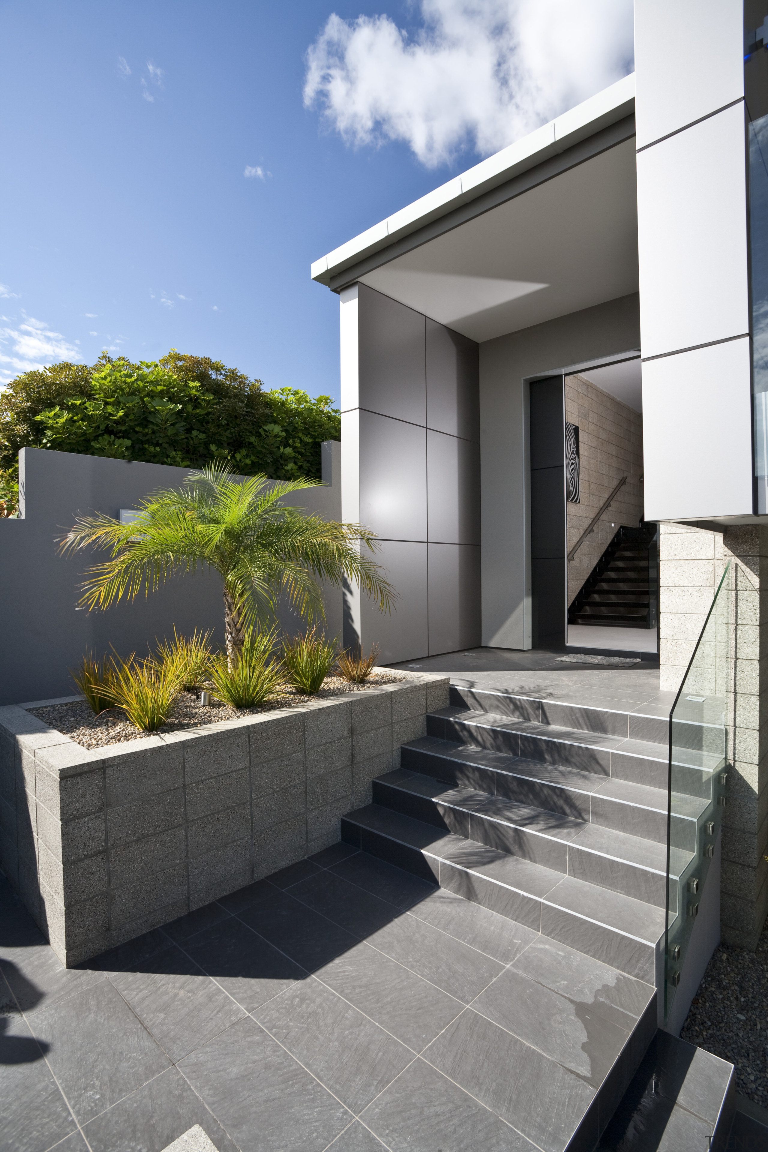 Exterior view of the entrance way which features apartment, architecture, condominium, facade, home, house, property, real estate, residential area, gray, black