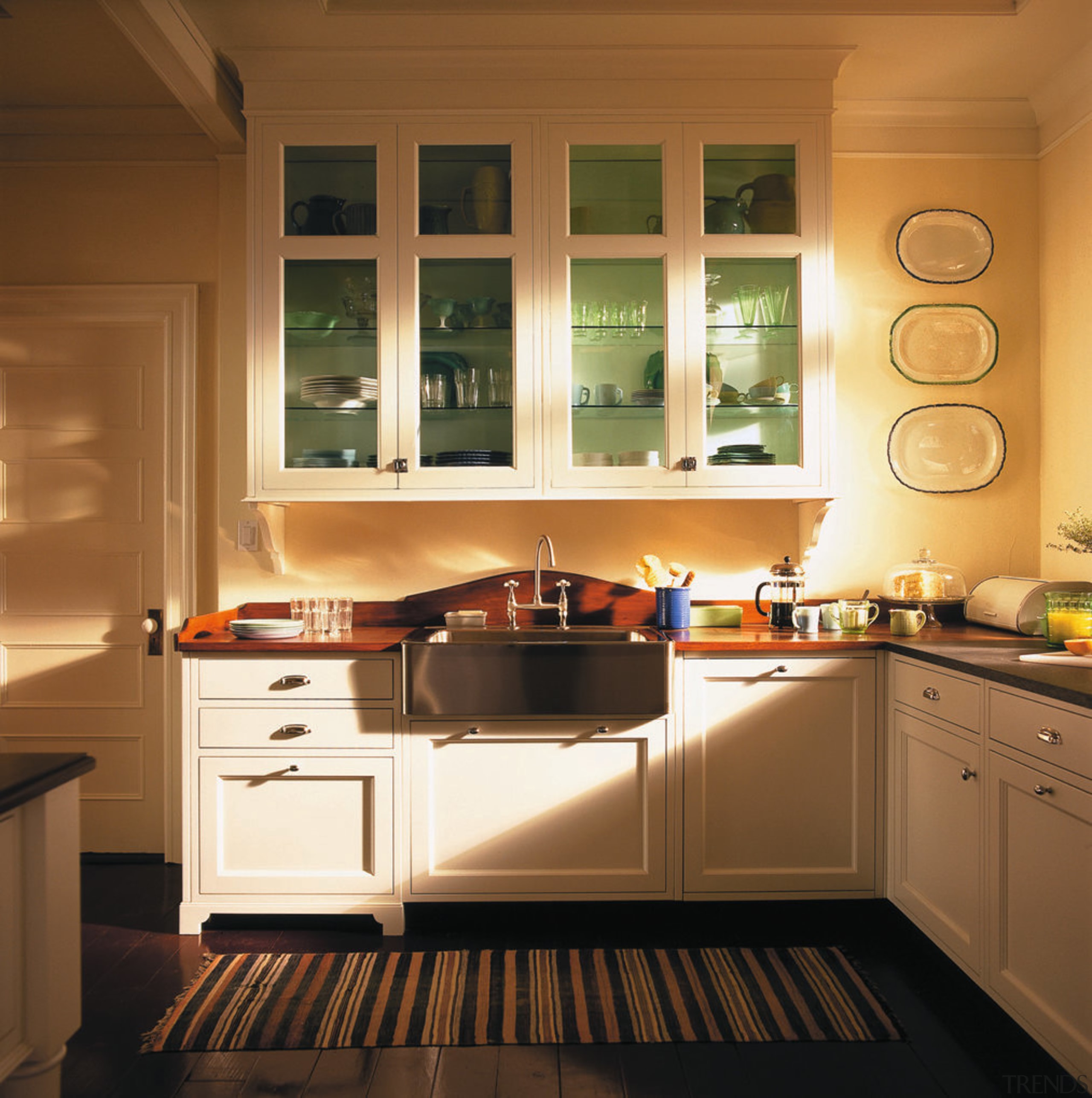 A view of this kitchen featuring traditional colonial cabinetry, countertop, cuisine classique, floor, flooring, furniture, hardwood, interior design, kitchen, room, under cabinet lighting, window, wood flooring, brown