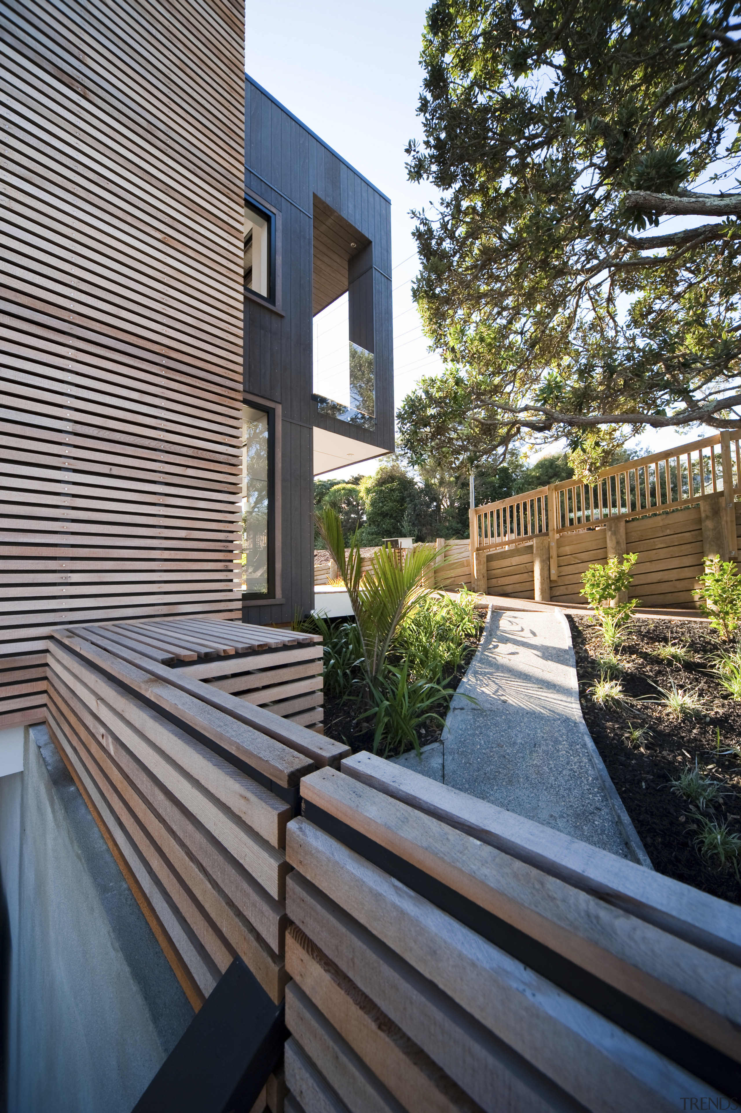 View of the Lite-House on Waiheke Island, a apartment, architecture, backyard, courtyard, deck, estate, facade, home, house, outdoor structure, property, real estate, residential area, siding, walkway, wood, gray