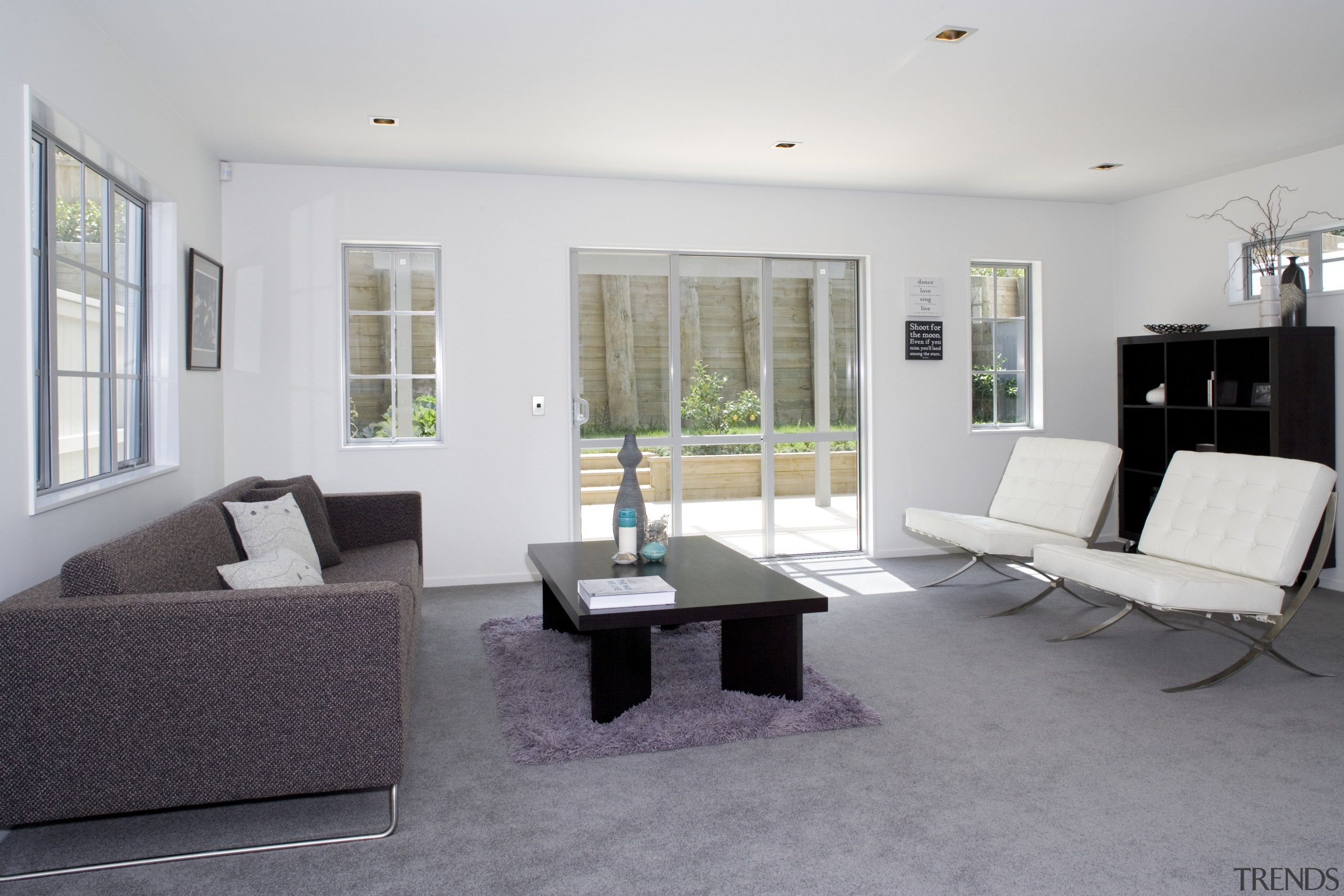 Living area inside contemporary townhouse created by Le architecture, floor, flooring, furniture, house, interior design, living room, property, real estate, room, table, gray, white