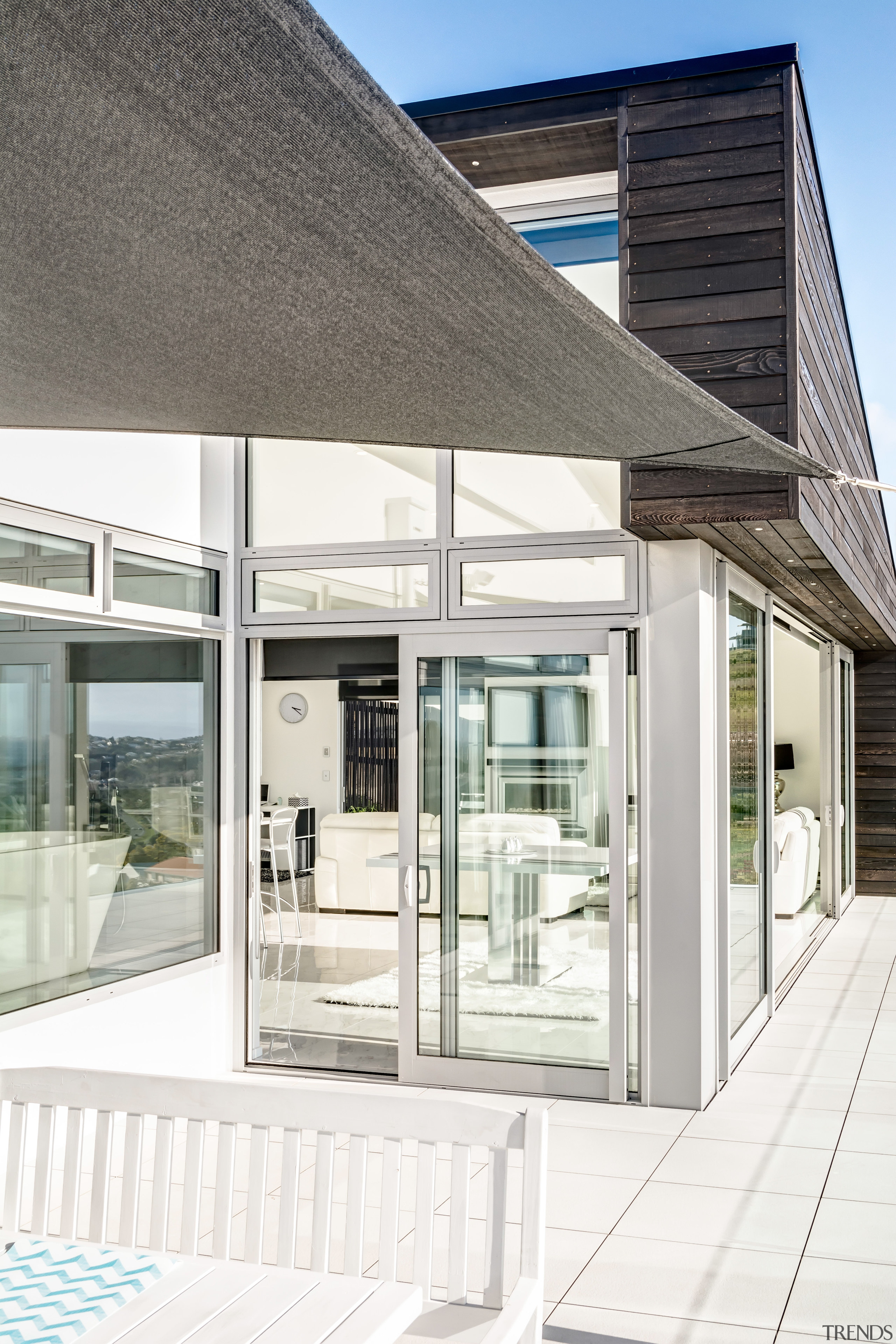 A sail shade shelters the outdoor dining area architecture, building, daylighting, facade, glass, house, window, white