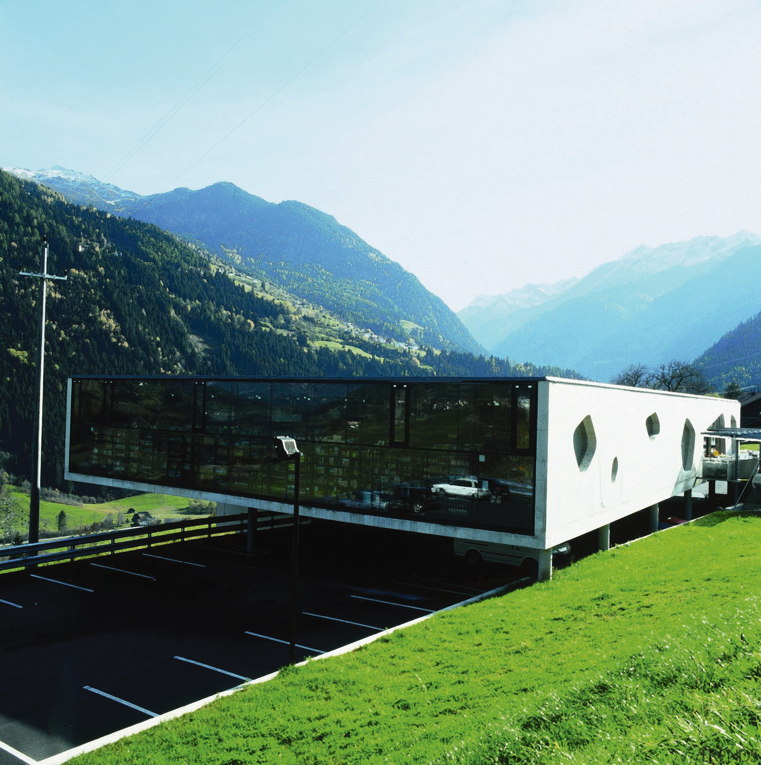 An exterior view of the architecturally design shopping alps, architecture, facade, grass, highland, hill station, house, landscape, mountain, mountain range, mountainous landforms, real estate, roof, sky, structure, white, black