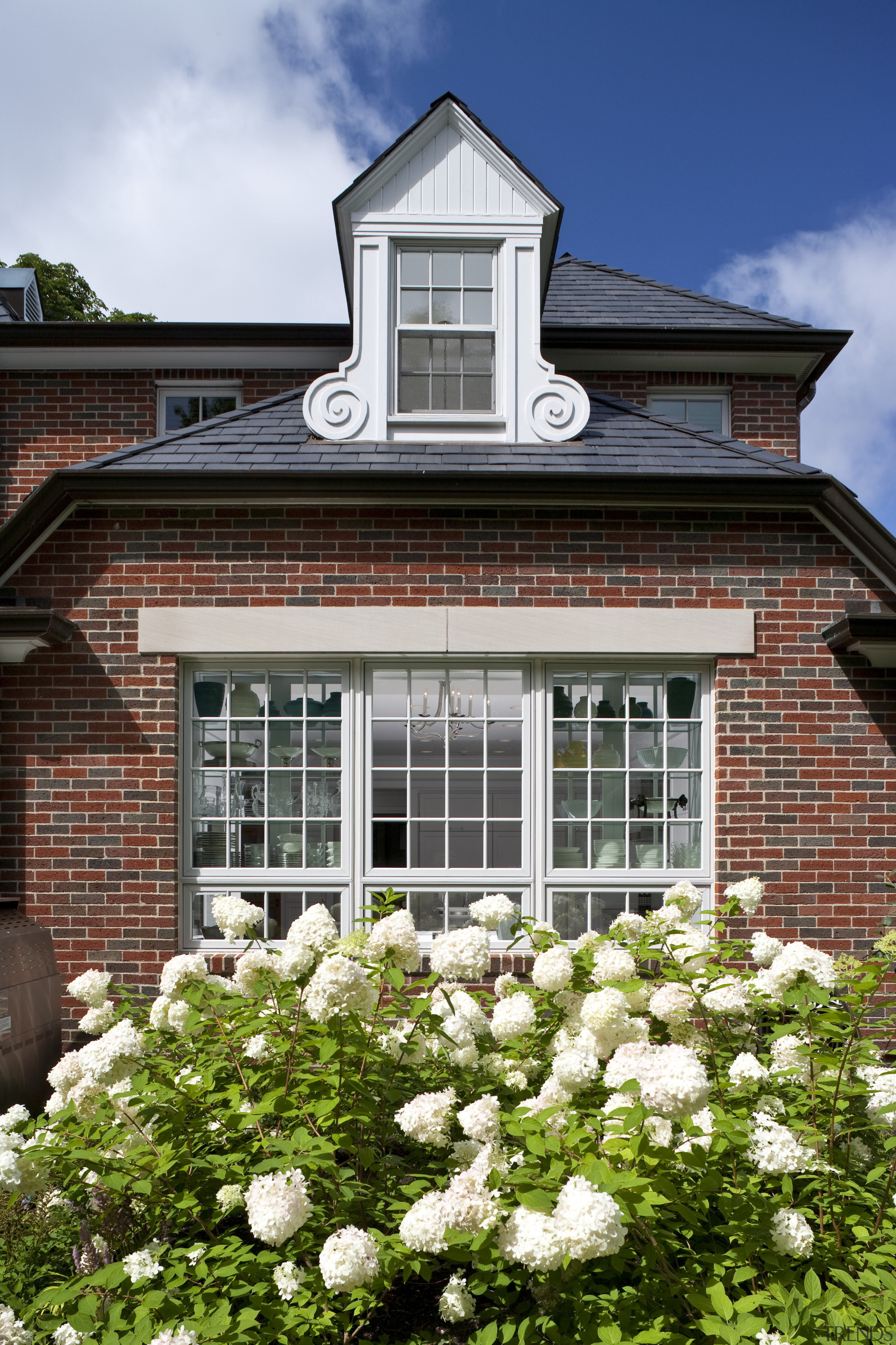 A view of a house by Julie Hacker building, cottage, estate, facade, flower, garden, home, house, plant, real estate, residential area, window, white