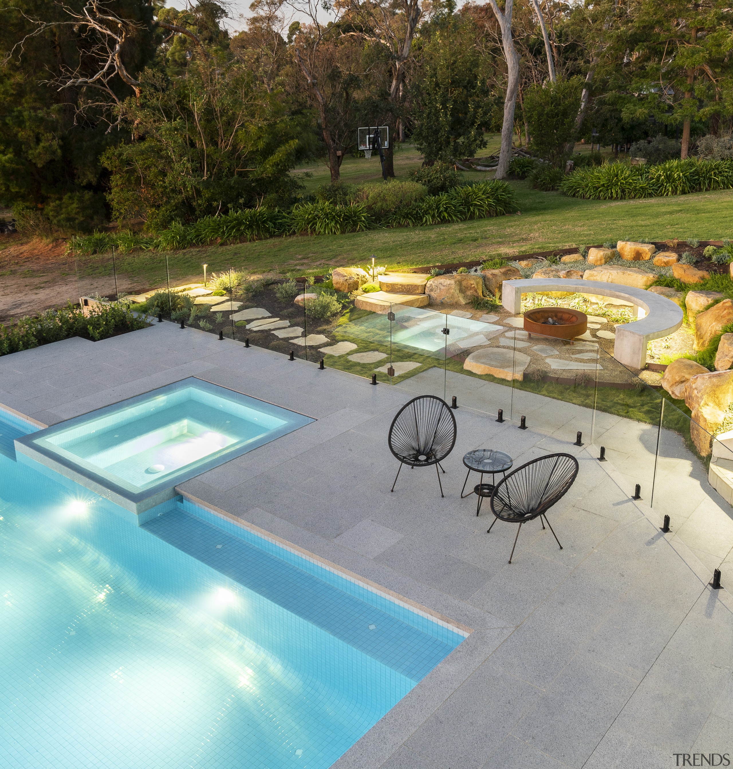 Pool, spa, and adjacent firepit at dusk. - 