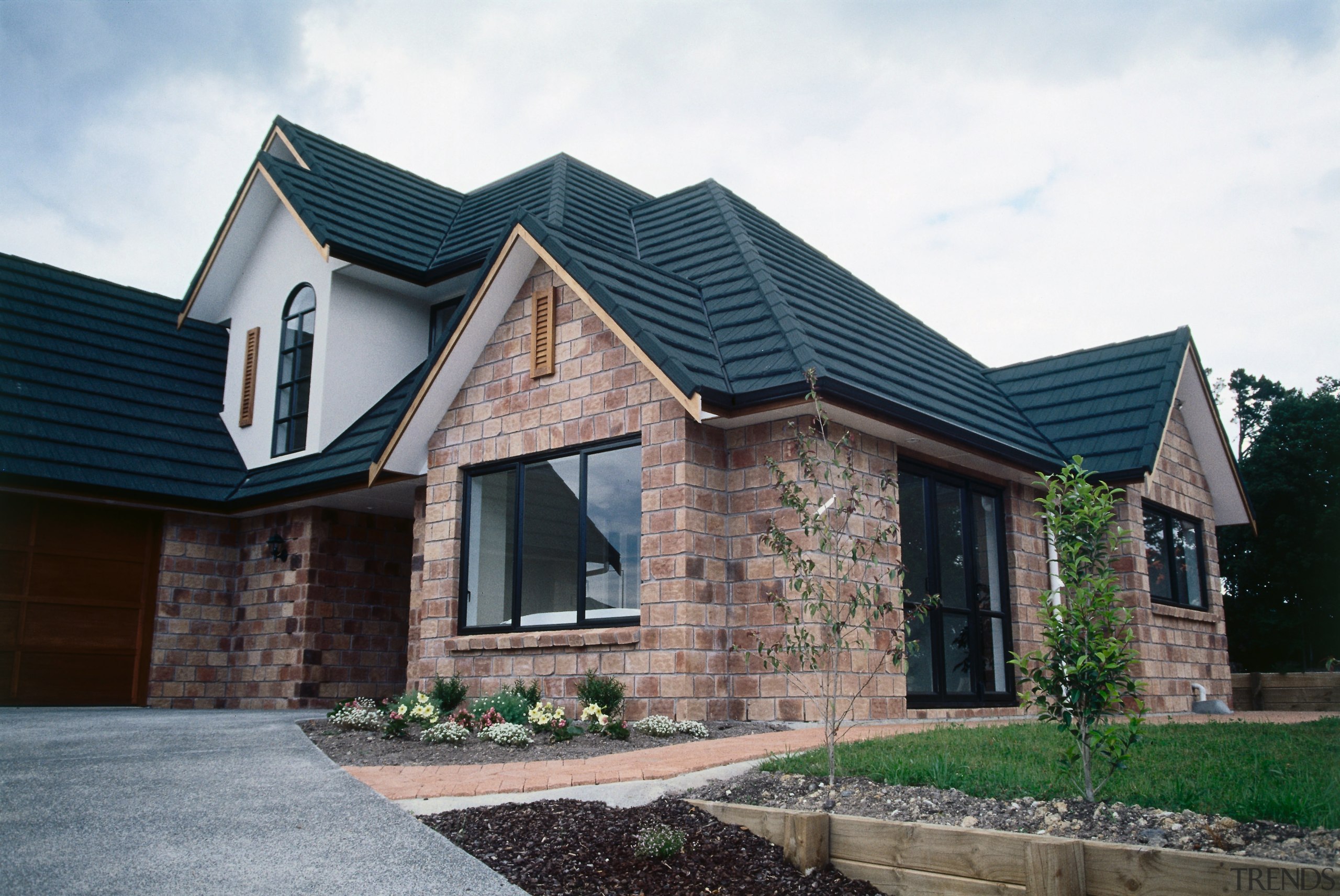 View of front of brick home with dark building, cottage, elevation, estate, facade, home, house, property, real estate, residential area, roof, siding, suburb, window, white, black