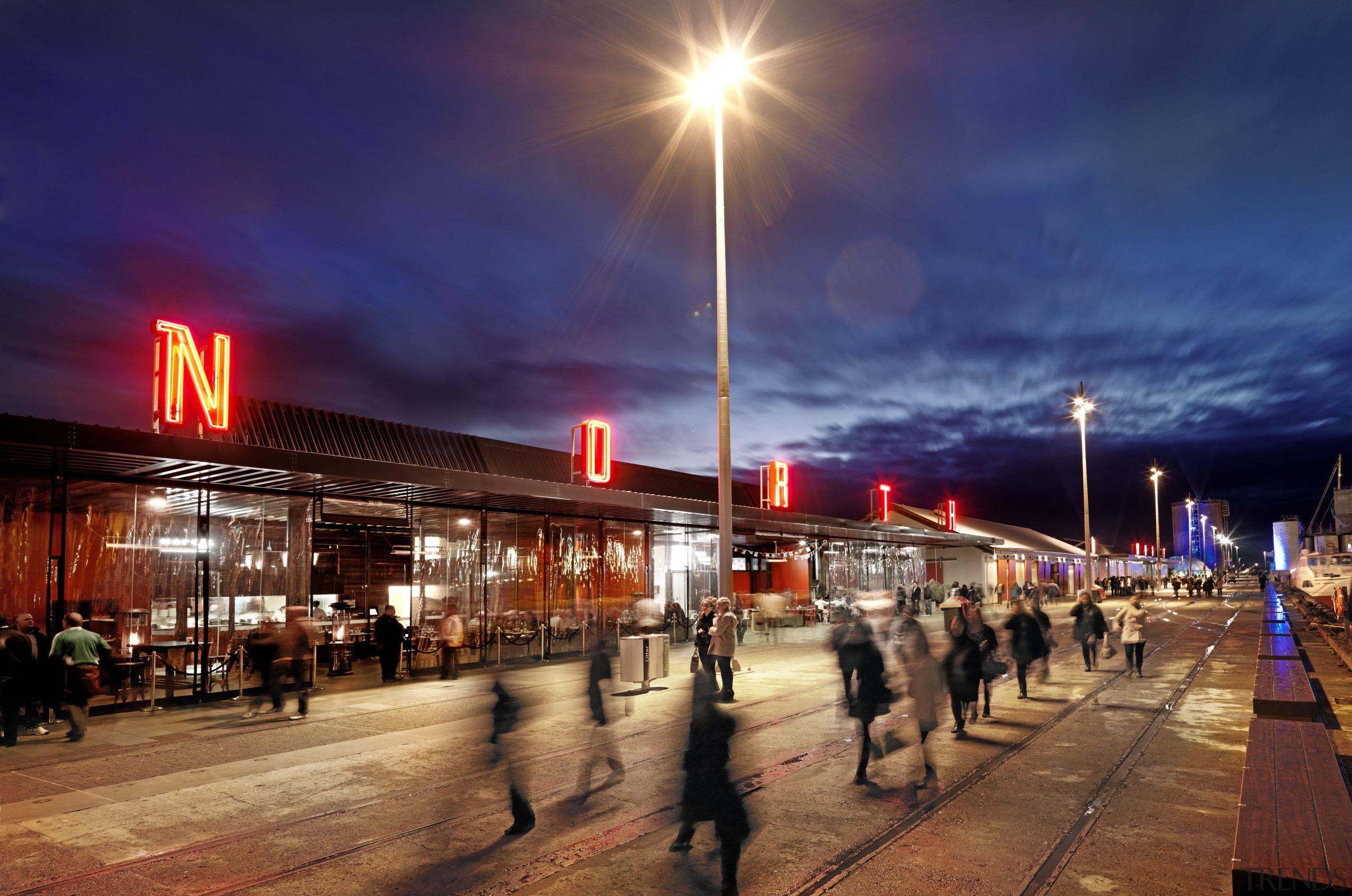 Waterfront area and night with people. - Waterfront boardwalk, city, downtown, dusk, evening, night, sky, street light, blue