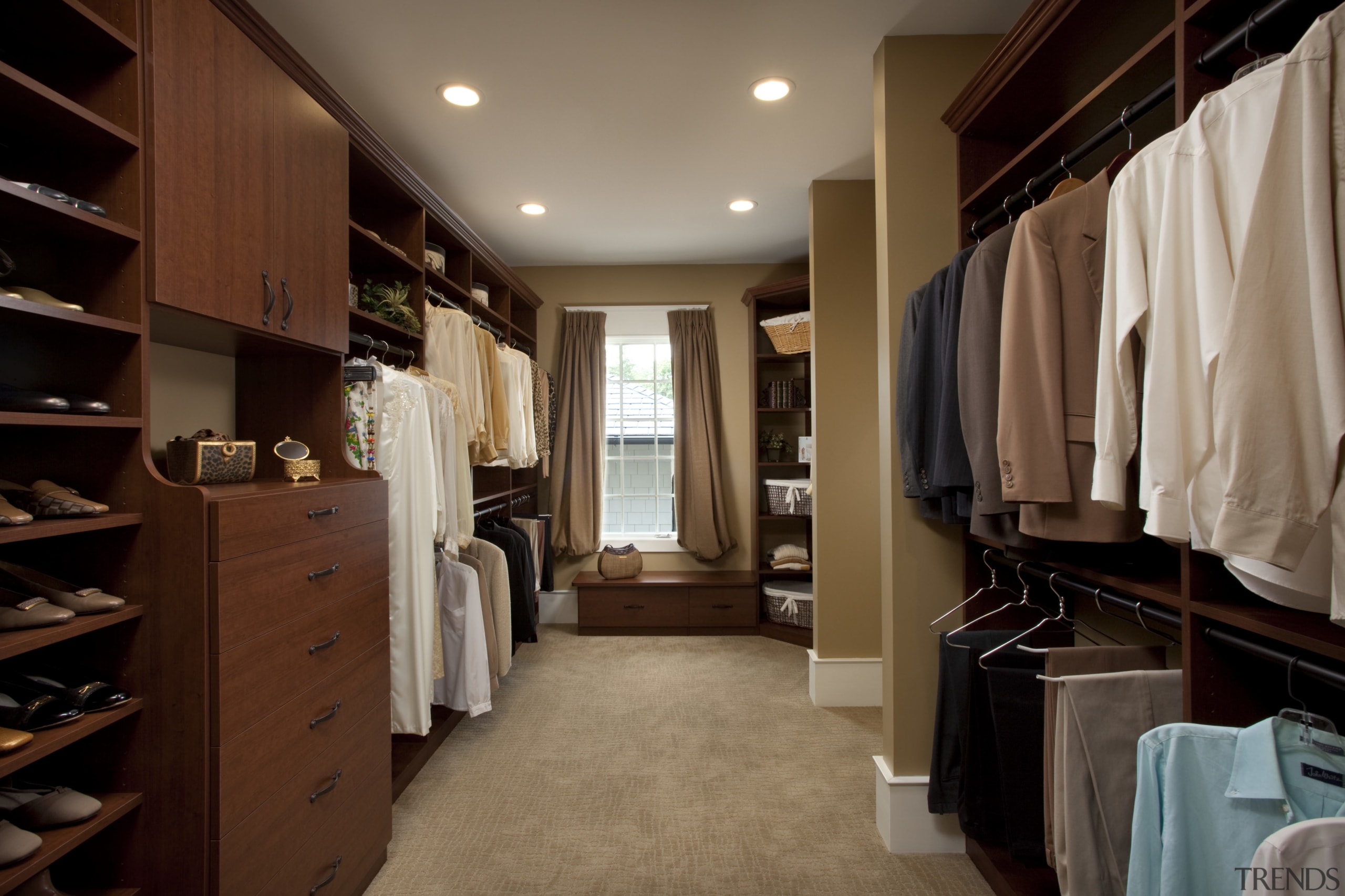 View of walk-in closet featuring shelving and storage. cabinetry, closet, furniture, interior design, room, wardrobe, brown, black