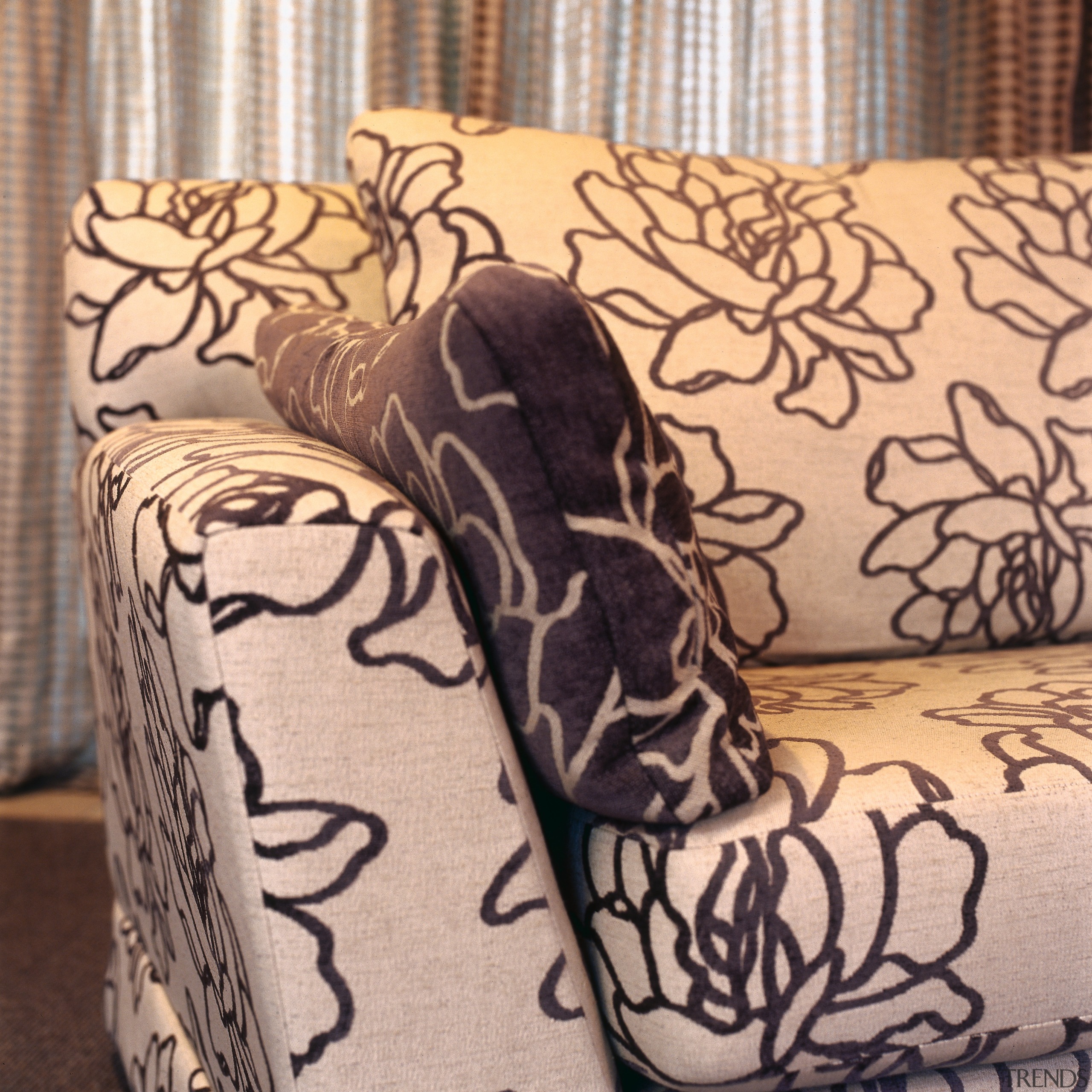 Closeup view of floral patterned sofa and cushion. orange