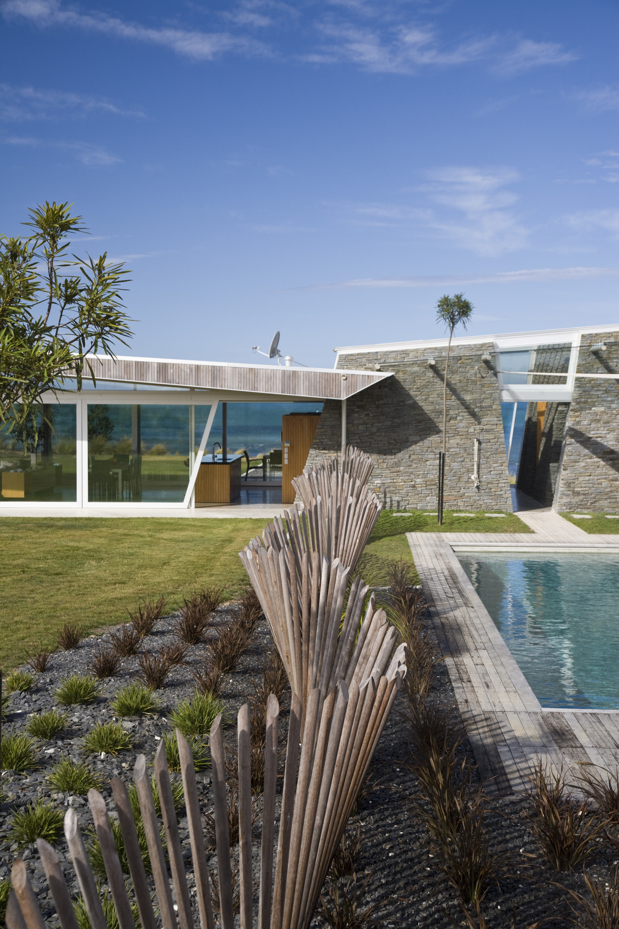 Exterior view of the outdoor area with pool, architecture, estate, home, house, landscape, plant, real estate, sky, water, teal