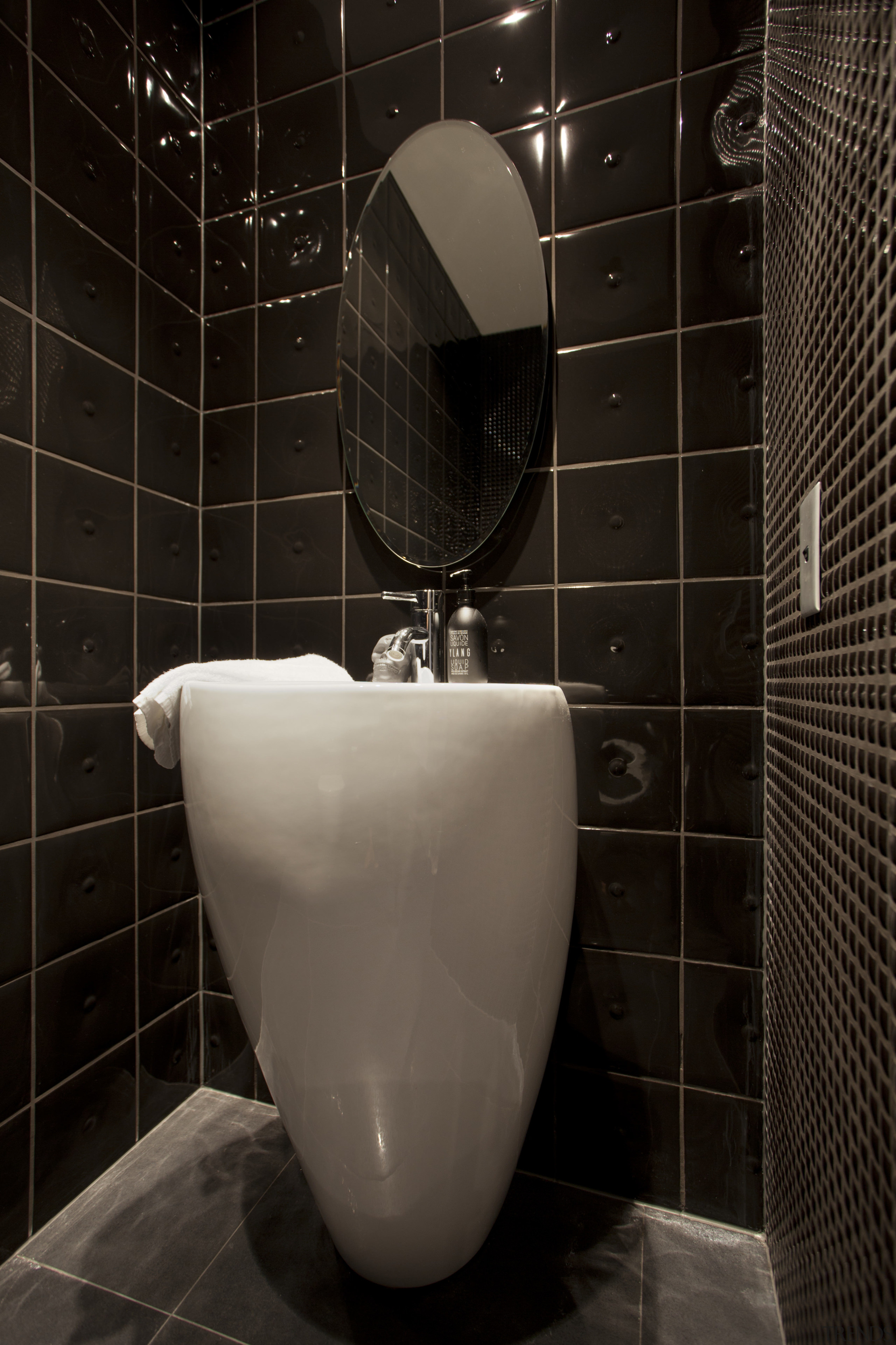 This home was designed by Allan Huntington of bathroom, ceramic, floor, flooring, interior design, plumbing fixture, product design, public toilet, room, tile, toilet, toilet seat, urinal, wall, black