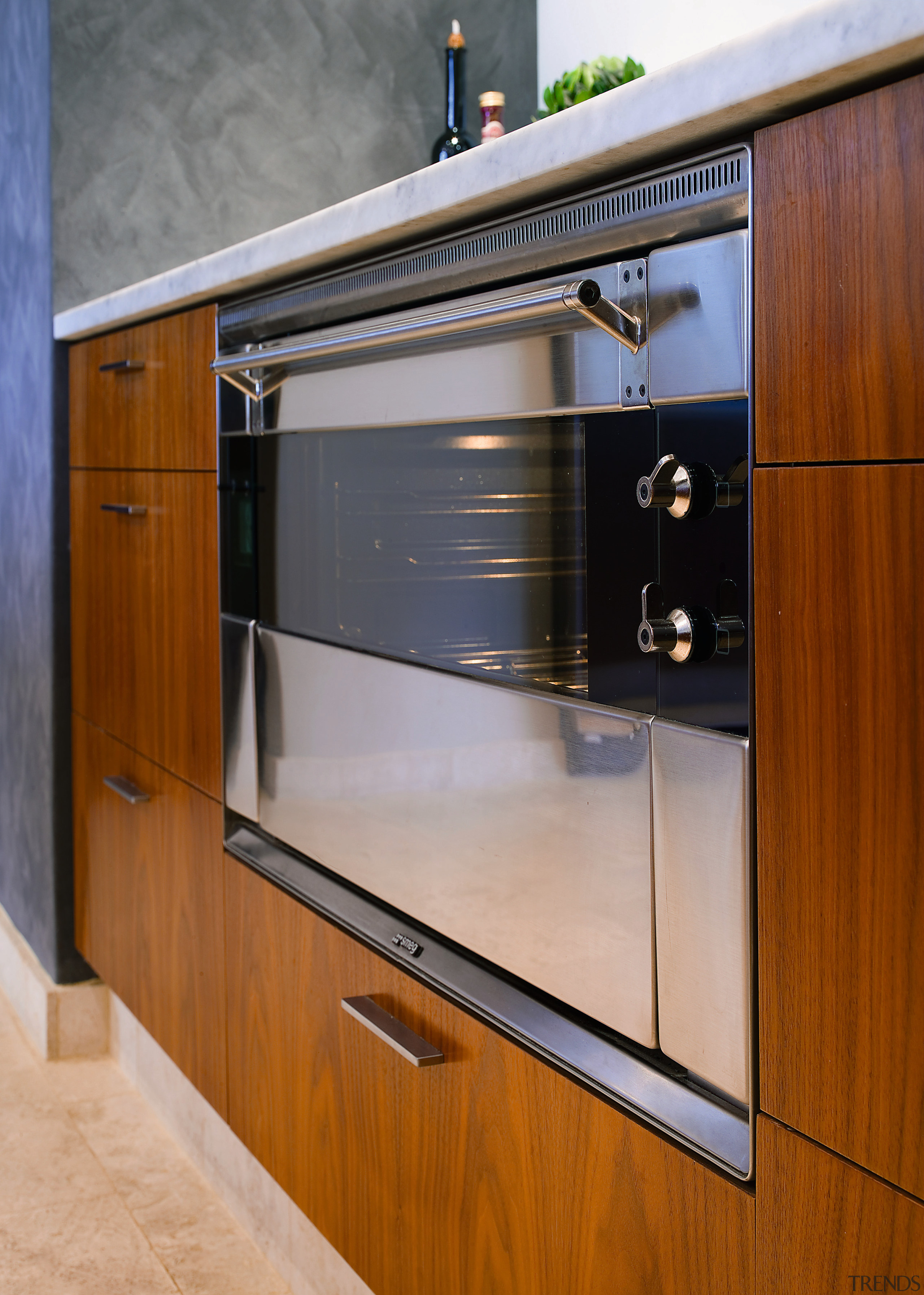 Closeup view of stainless steel oven set into cabinetry, countertop, furniture, home appliance, kitchen, major appliance, gray, brown