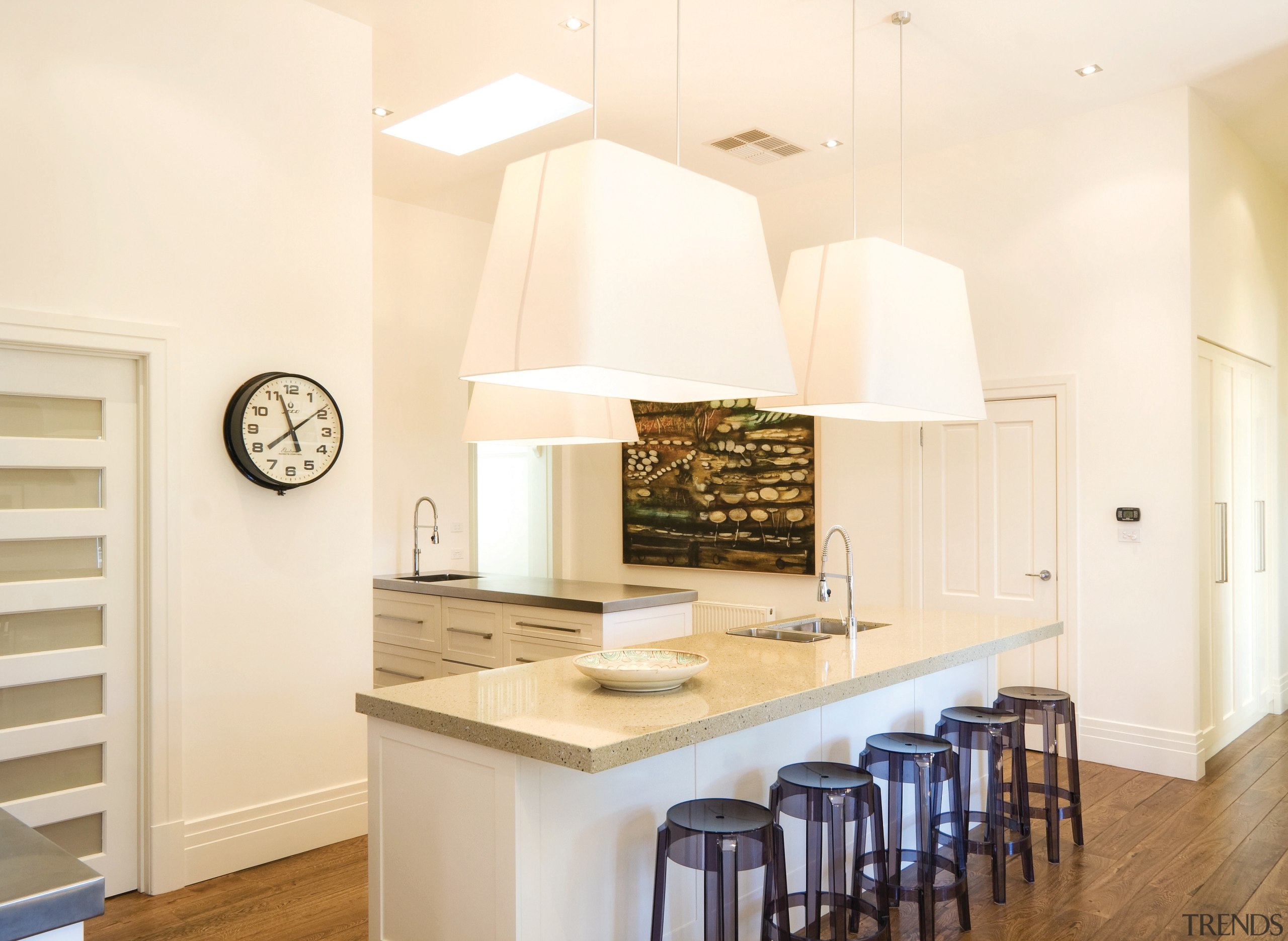 View of a kitchen featuring long island with ceiling, countertop, cuisine classique, floor, flooring, home, interior design, kitchen, real estate, room, white