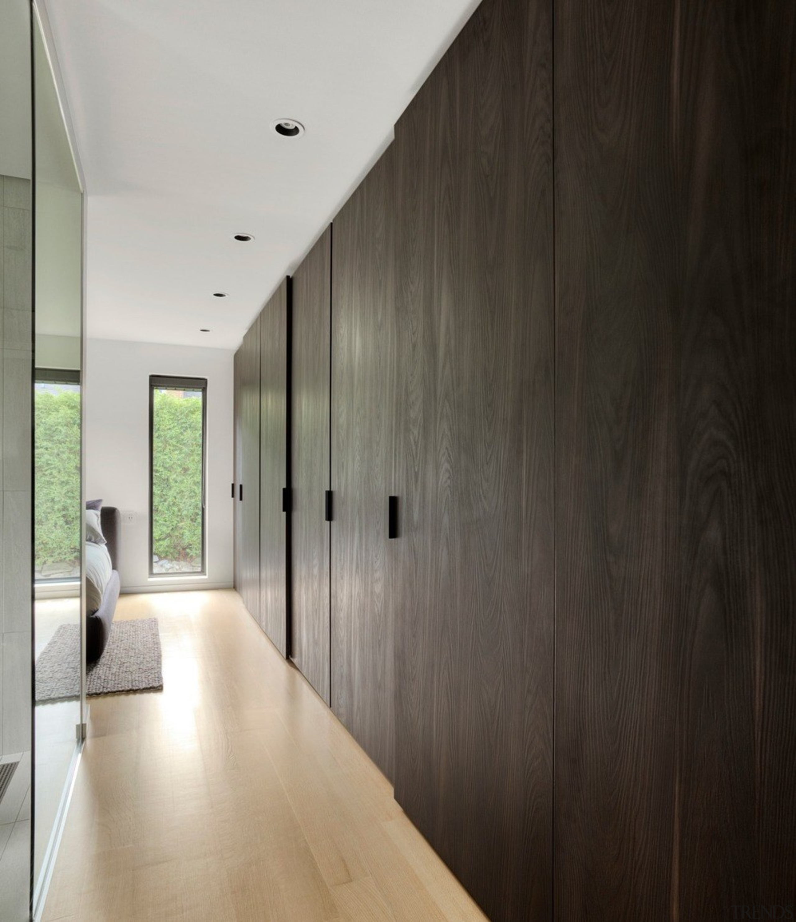 A long line of dark timber coloured cabinetry architecture, building, ceiling, concrete, design, floor, flooring, furniture, hall, hardwood, home, house, interior design, loft, plywood, property, room, space, wall, wood, wood flooring, gray, black