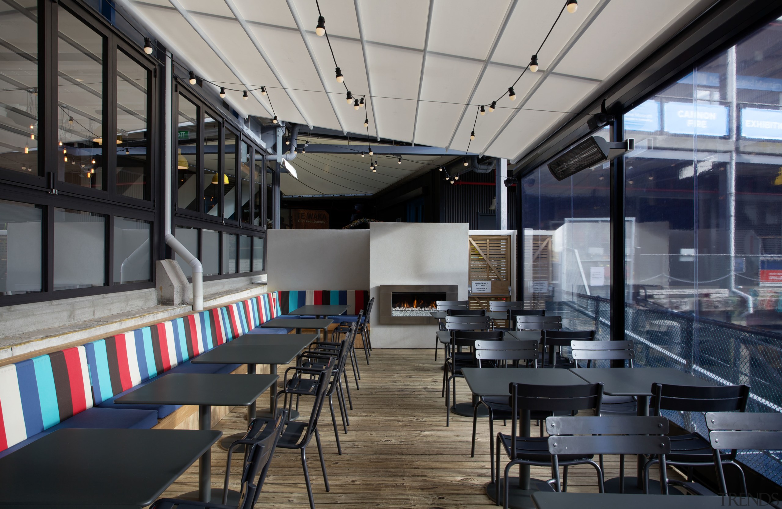 An outdoor fireplace is a feature of the café, interior design, restaurant, black, gray