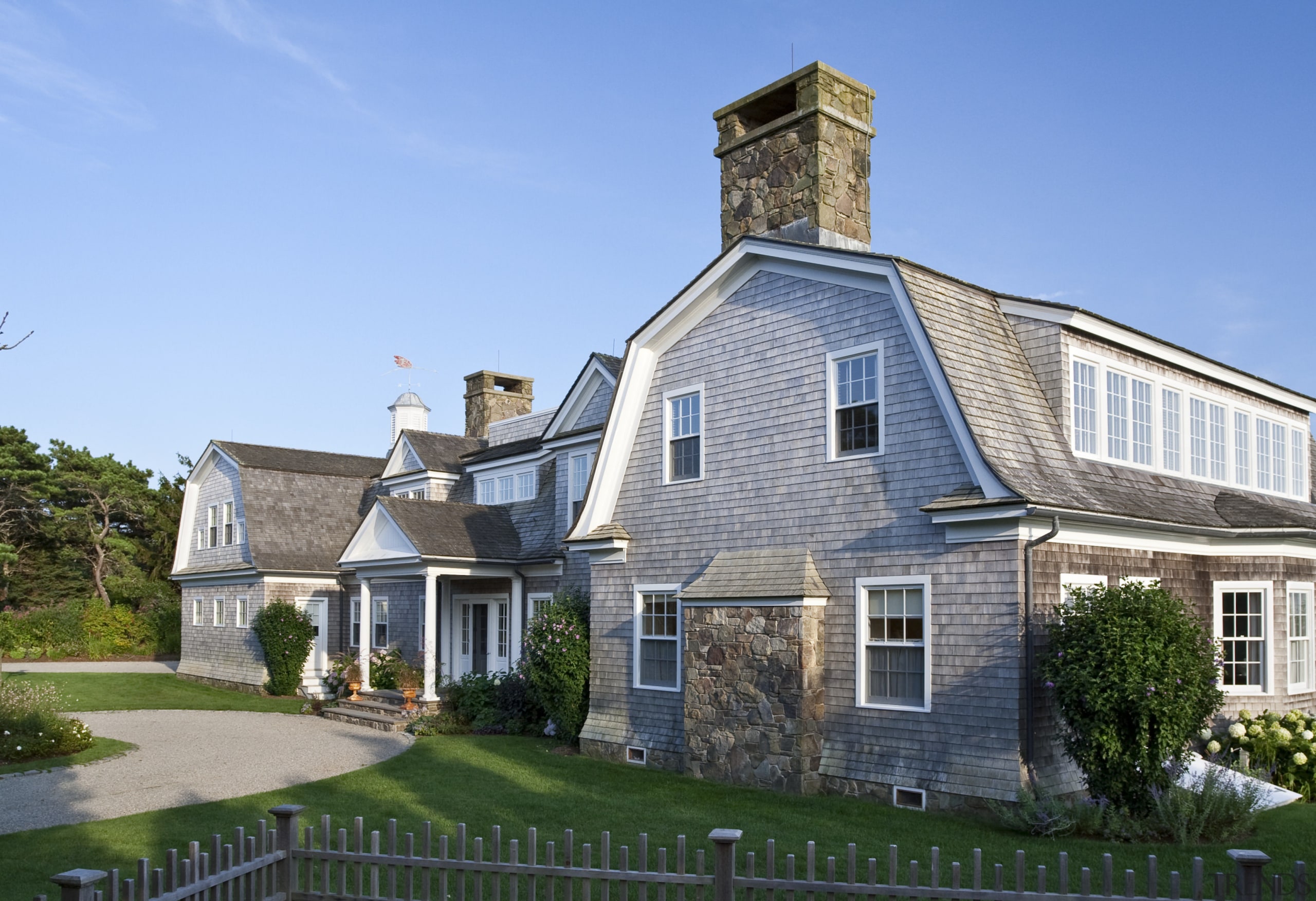 Exterior view of a New-England styled vacation home. building, cottage, estate, facade, farmhouse, historic house, home, house, mansion, neighbourhood, property, real estate, residential area, roof, siding, sky, suburb, window, teal