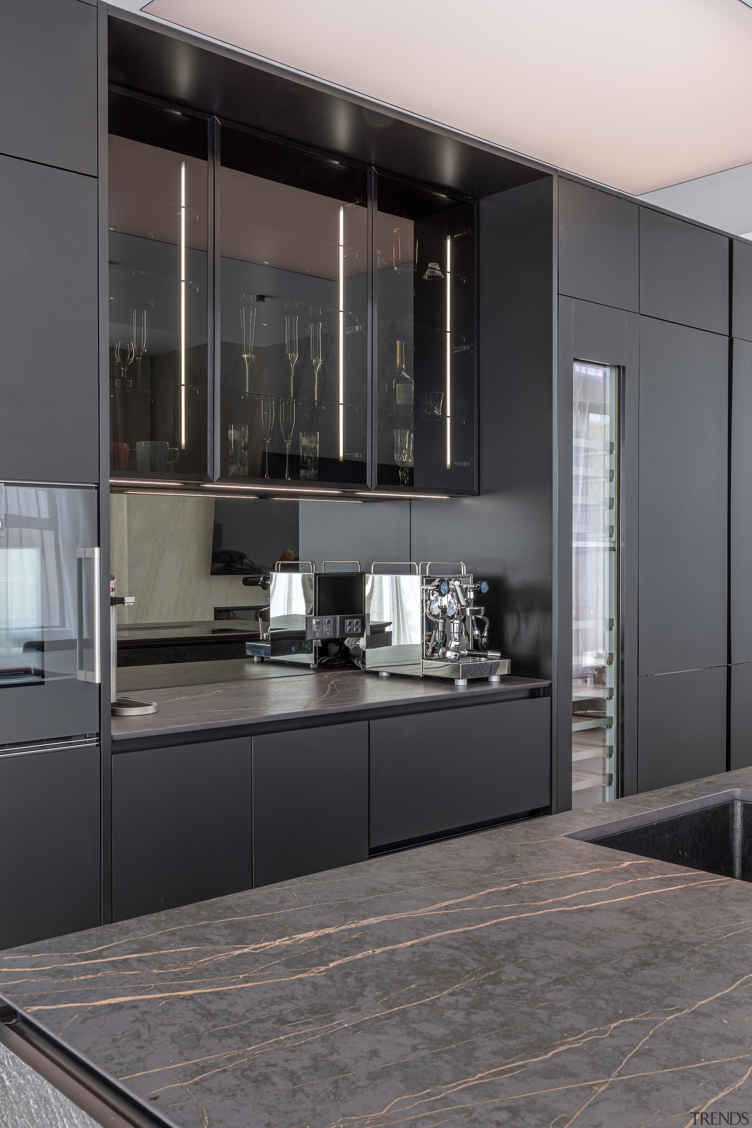 The glass-fronted cabinets with internal LED lighting create 