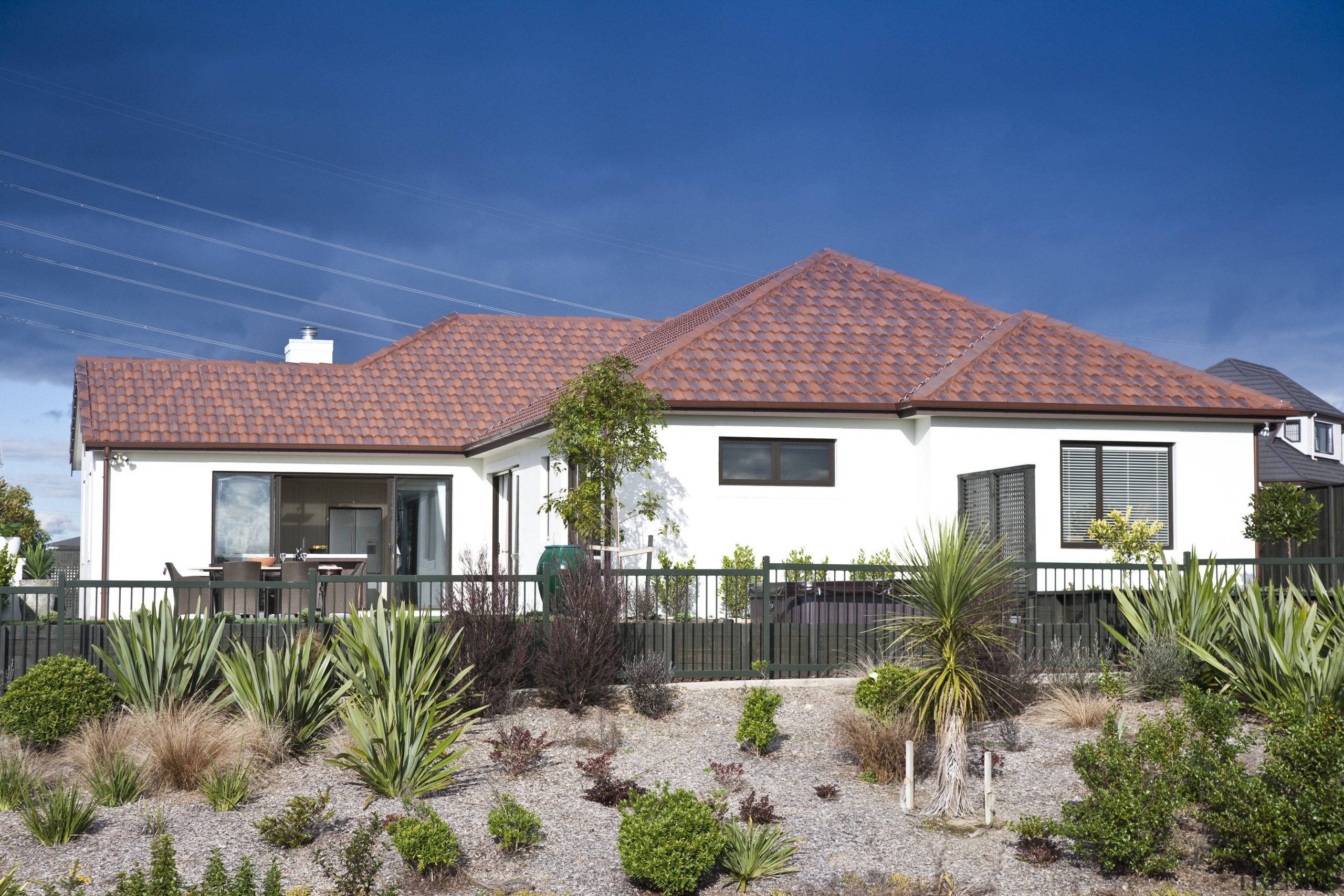 Exterior view of home featuring brick cladding, doors cottage, elevation, estate, facade, farmhouse, home, house, land lot, property, real estate, residential area, roof, sky, villa, yard, blue