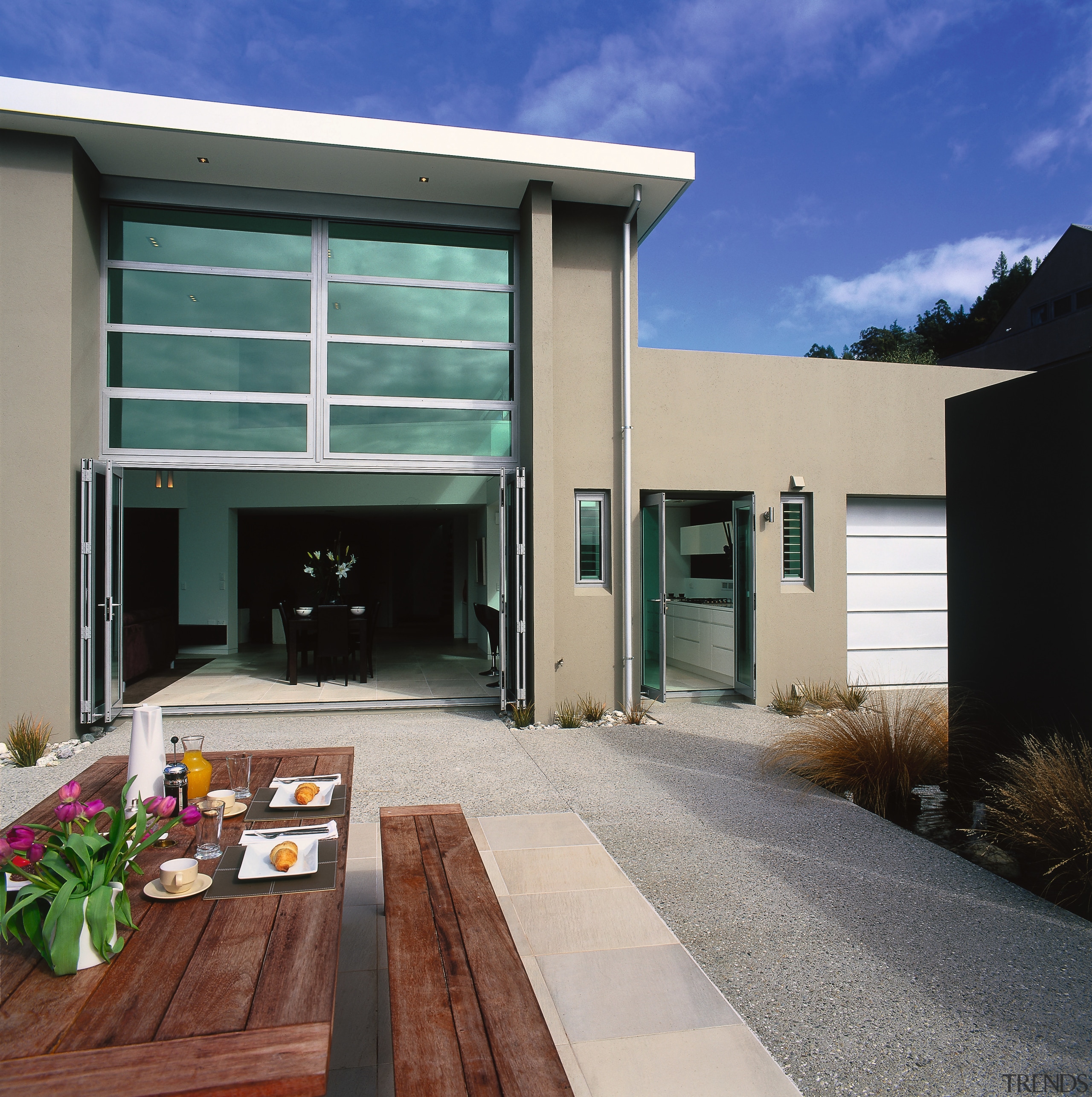 An exterior view of a patio area, grey architecture, door, elevation, facade, home, house, property, real estate, residential area, siding, window, gray