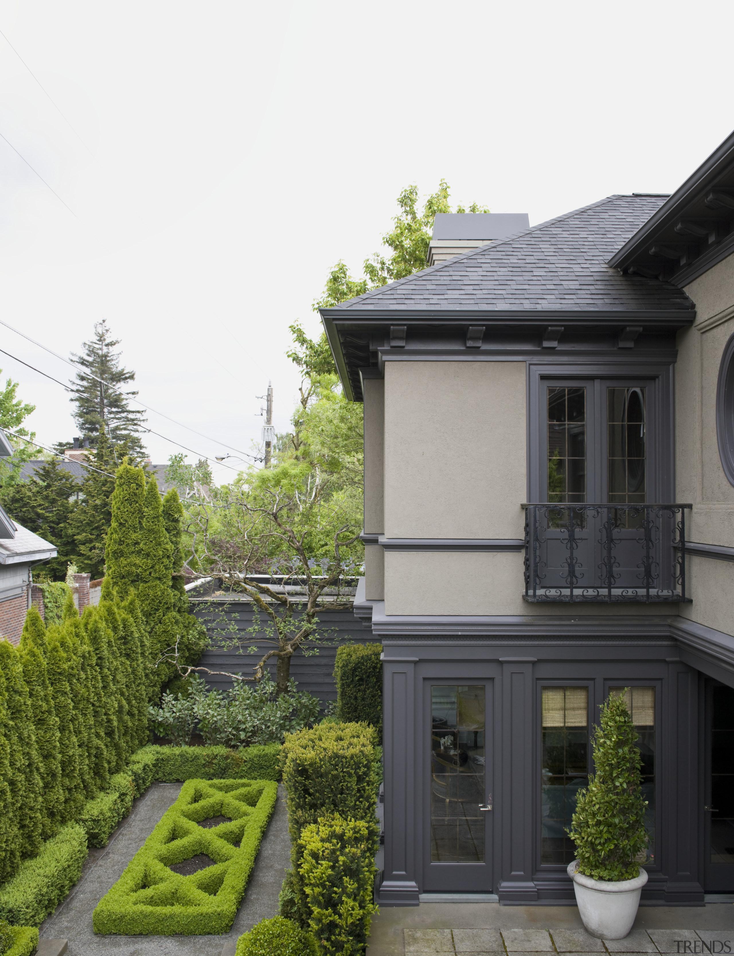 Exterior view of century old house featuring landscaping, architecture, cottage, estate, facade, garden, grass, home, house, landscaping, mansion, neighbourhood, outdoor structure, plant, property, real estate, residential area, roof, siding, tree, window, yard, white