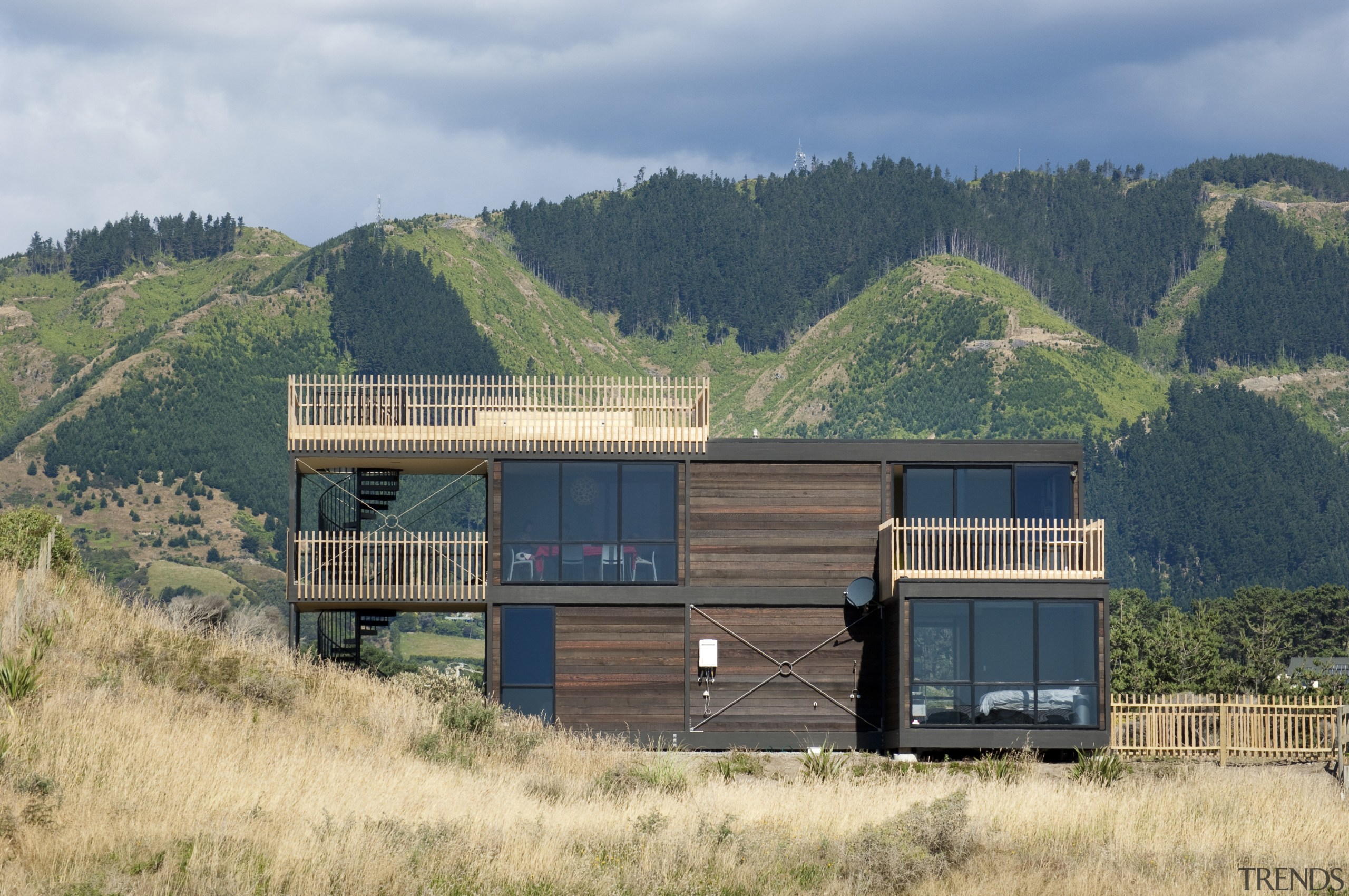 View of contempoary multilevel home. - View of home, house, landscape, mountain, real estate, rural area, shack, sky, transport, teal