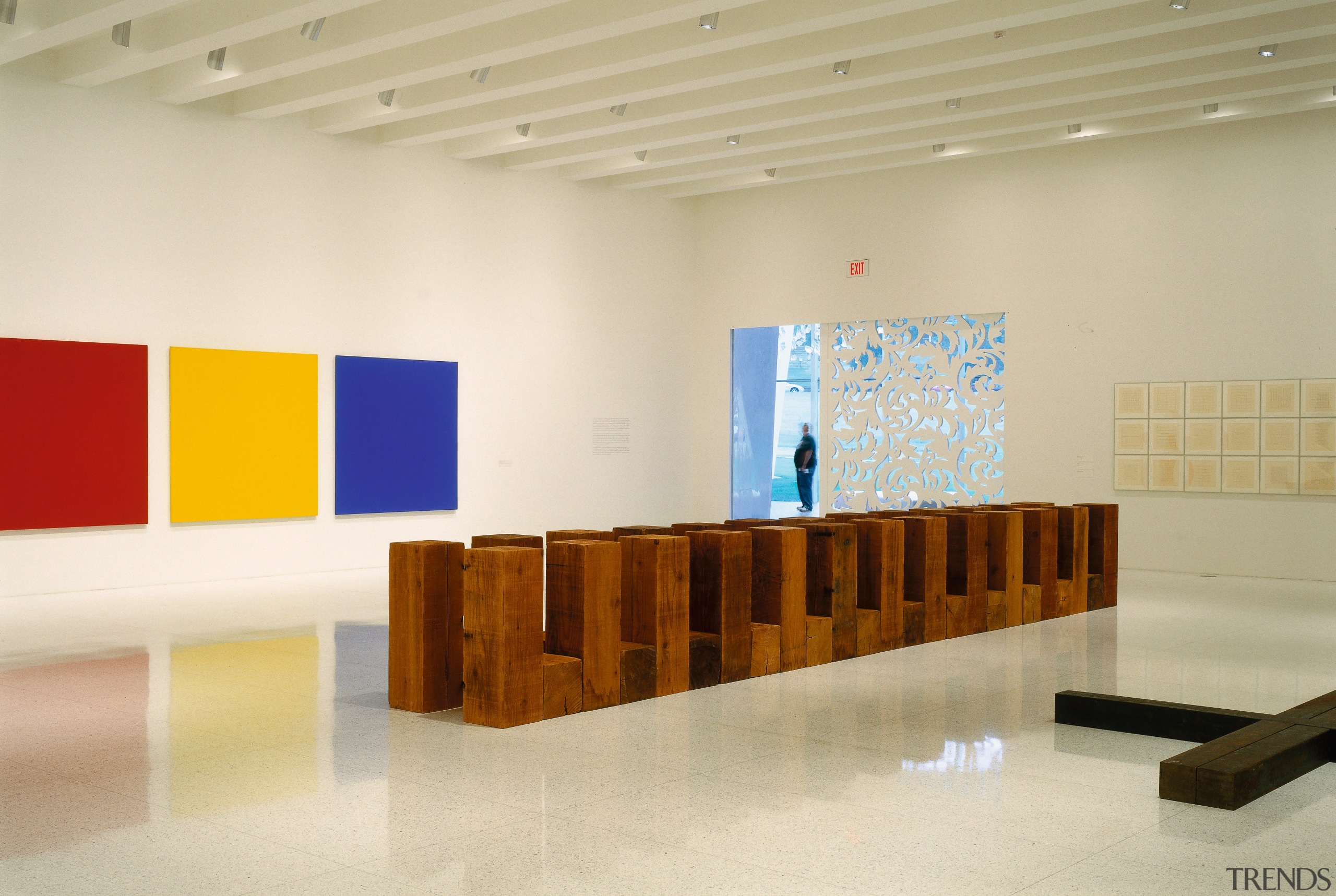 One of the rooms within the gallery displaying architecture, art gallery, exhibition, floor, flooring, furniture, interior design, product design, table, tourist attraction, wood, orange