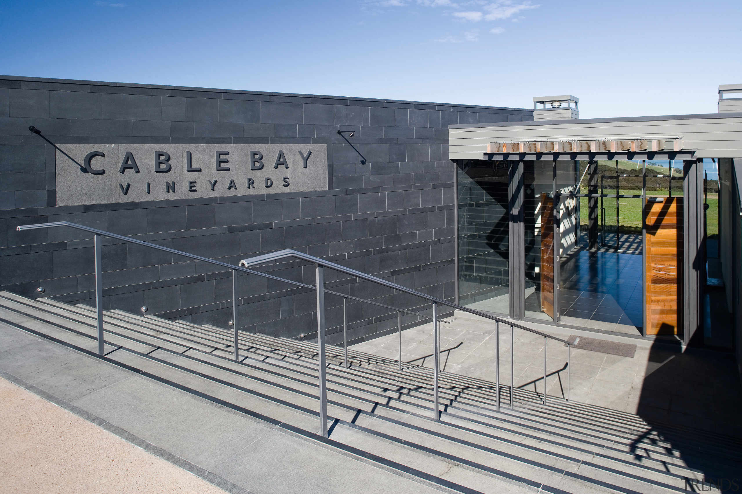 The entrance brings patrons downstairs into a foyer architecture, building, structure, gray