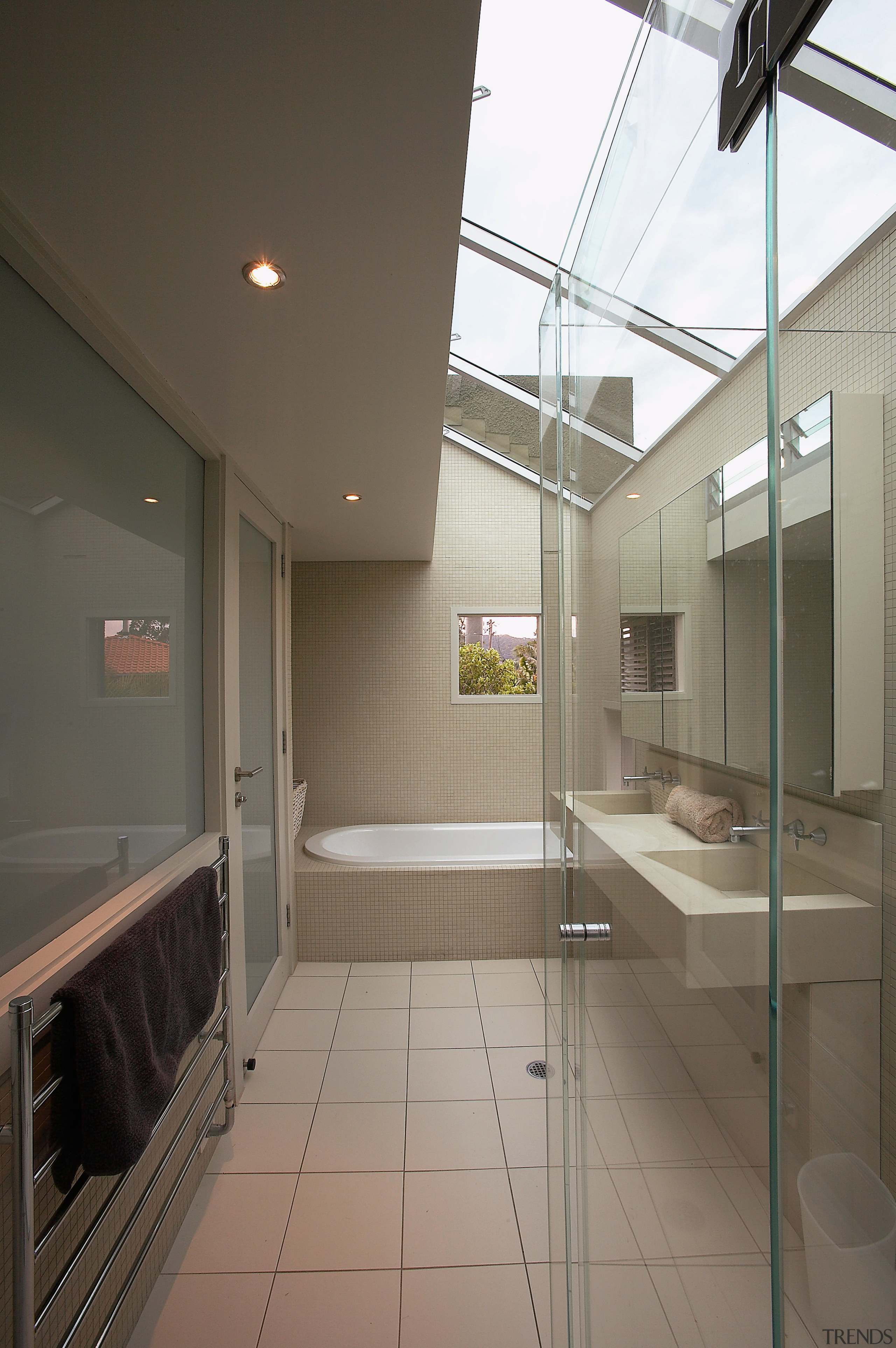 A view of the bathrom featuring tiled walls/flooring, architecture, ceiling, daylighting, floor, glass, interior design, real estate, window, gray