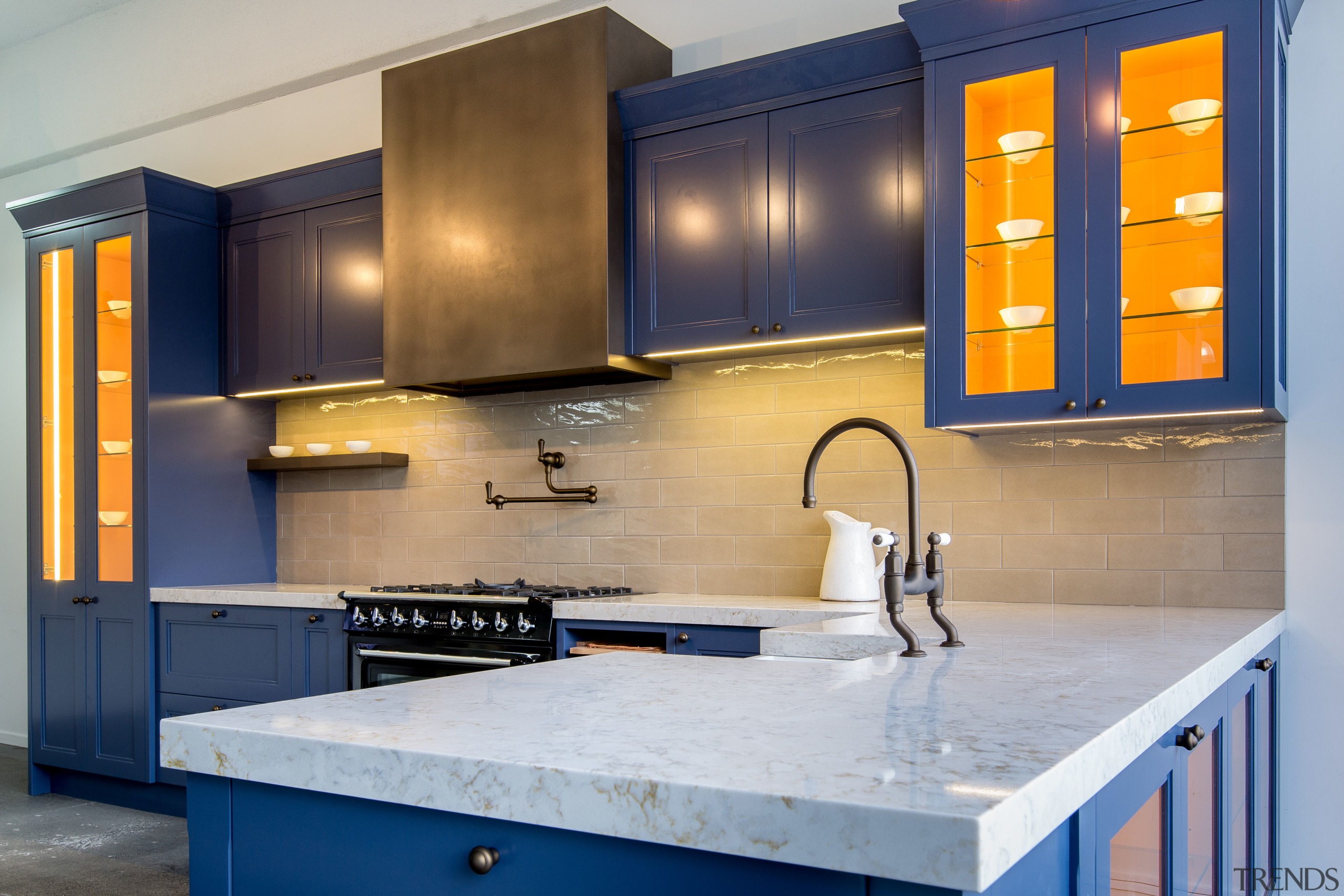 White stone counters and blue cabinetry create a cabinetry, countertop, kitchen, room, gray