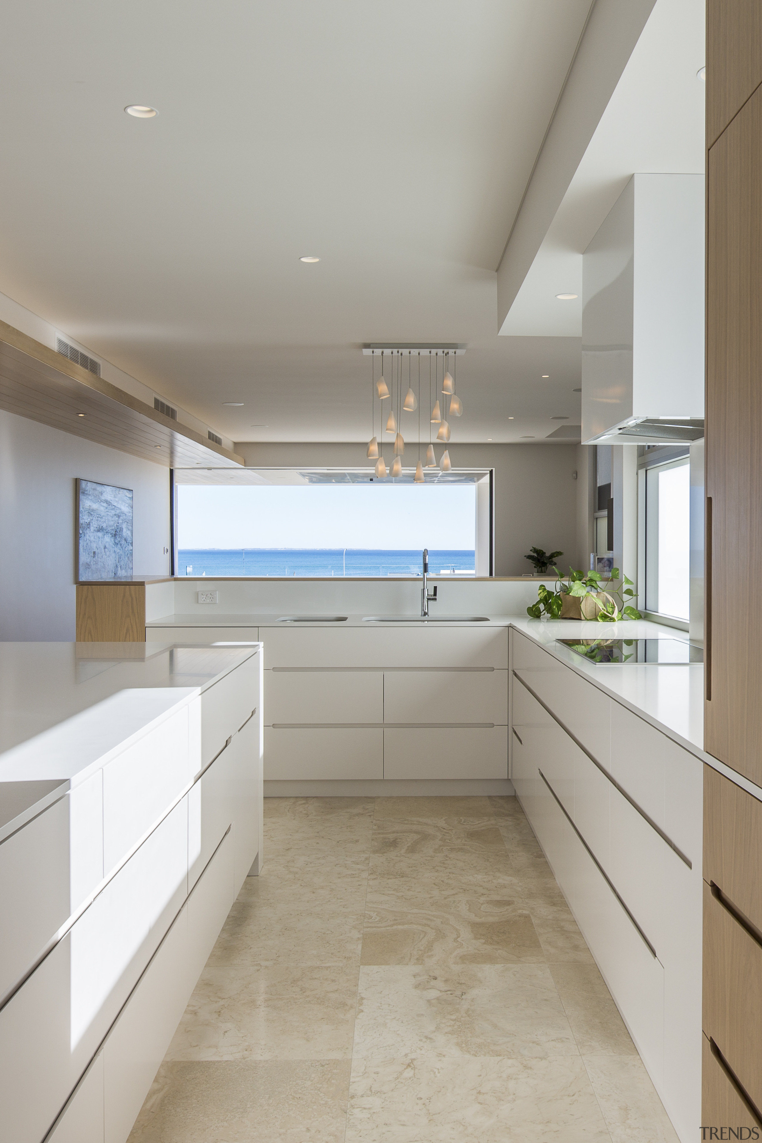 This crisp white and wood kitchen part of cabinetry, countertop, ceasarstone, benchtop, travertine floor, kitchen, Craig Steere