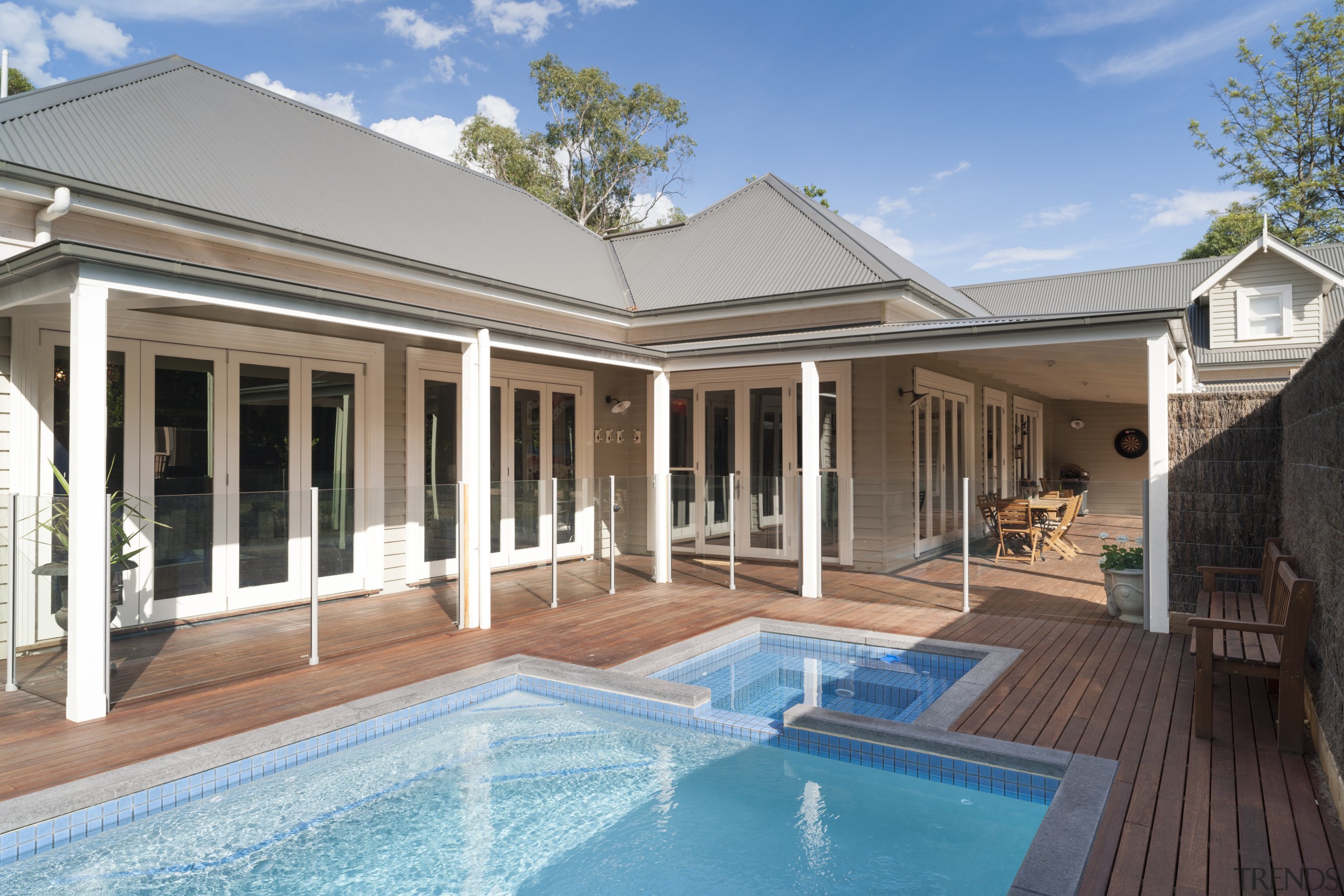 The covered deck at the rear of this estate, facade, home, house, outdoor structure, property, real estate, swimming pool, villa, window, teal