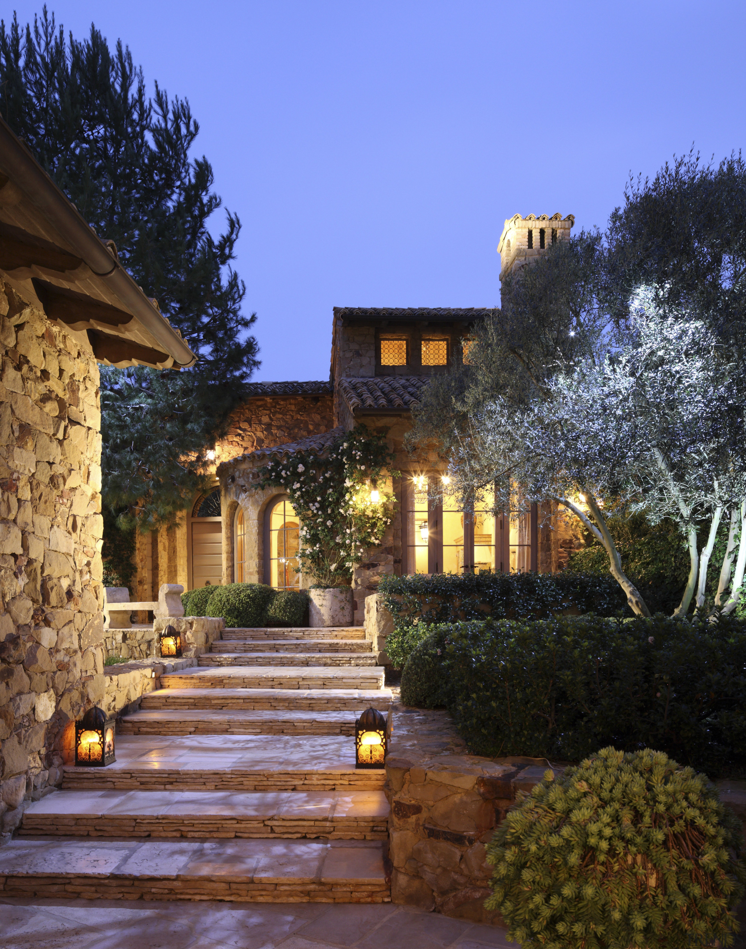 View of steps up to entrance way of architecture, cottage, courtyard, estate, evening, facade, hacienda, home, house, landscape, landscape lighting, landscaping, lighting, mansion, outdoor structure, property, real estate, residential area, sky, villa