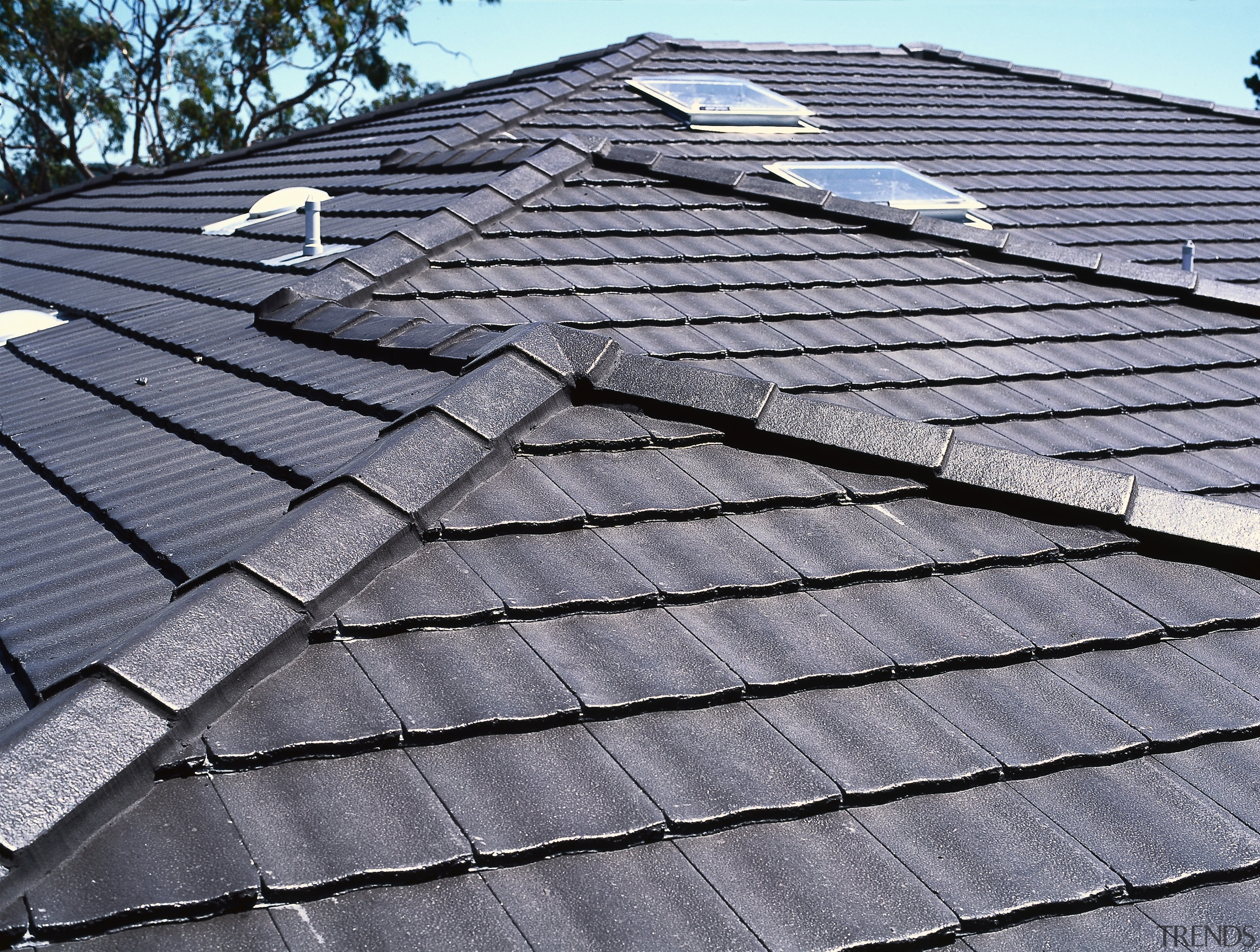 Closeup of grey concrete tiles on roof, with daylighting, facade, line, roof, sky, slate, wood, gray