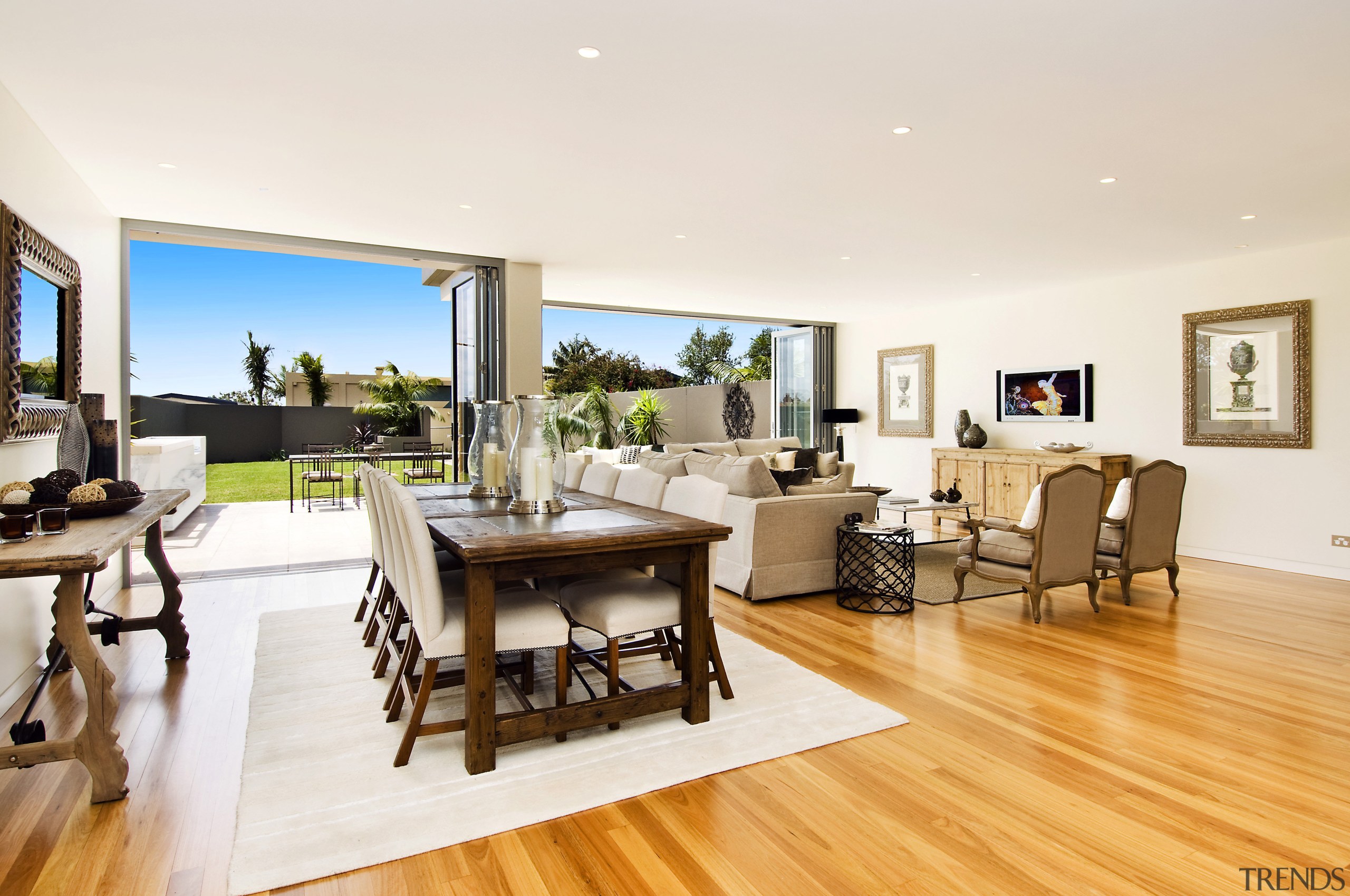 View of apartment with lounge opening out to dining room, floor, flooring, interior design, living room, property, real estate, table, white