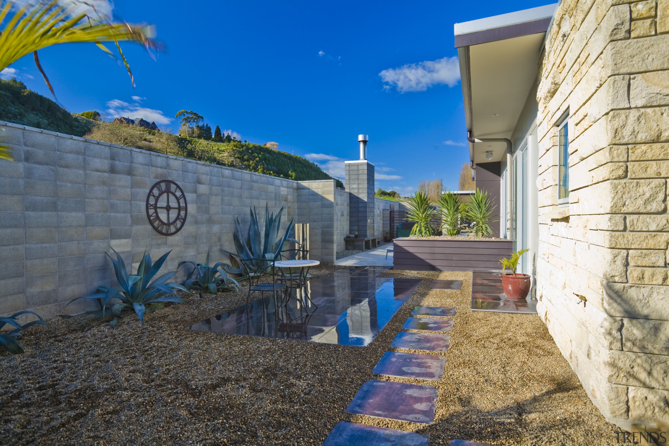 A view of the side of the house blue, facade, home, house, landscape, neighbourhood, plant, real estate, sky, tree, wall, water