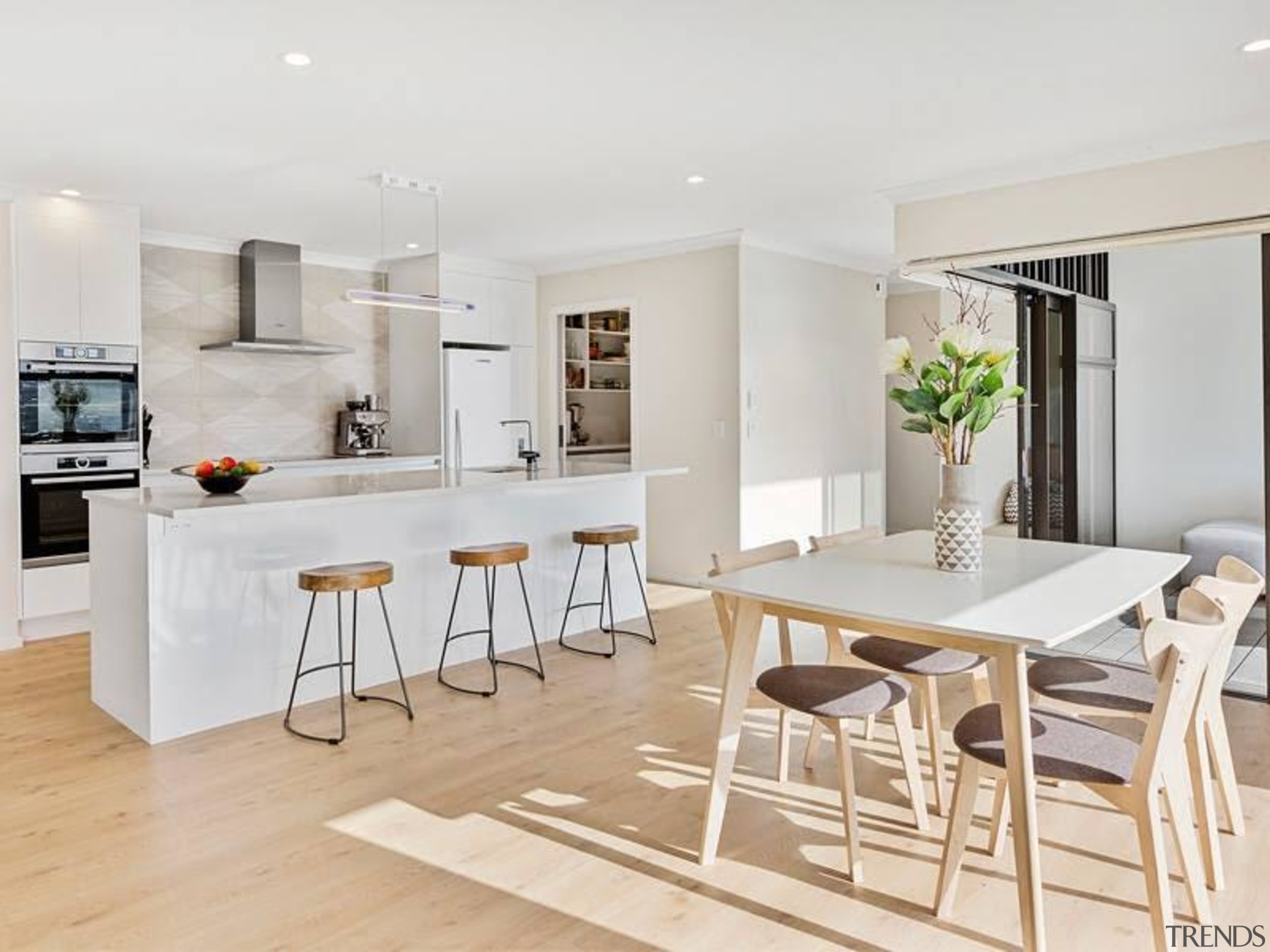 Window placement ensured this family kitchen and dining bar stool, building, cabinetry, ceiling, chair, dining room, floor, flooring, furniture, home, house, interior design, kitchen, laminate flooring, living room, material property, property, real estate, room, table, wood flooring, white