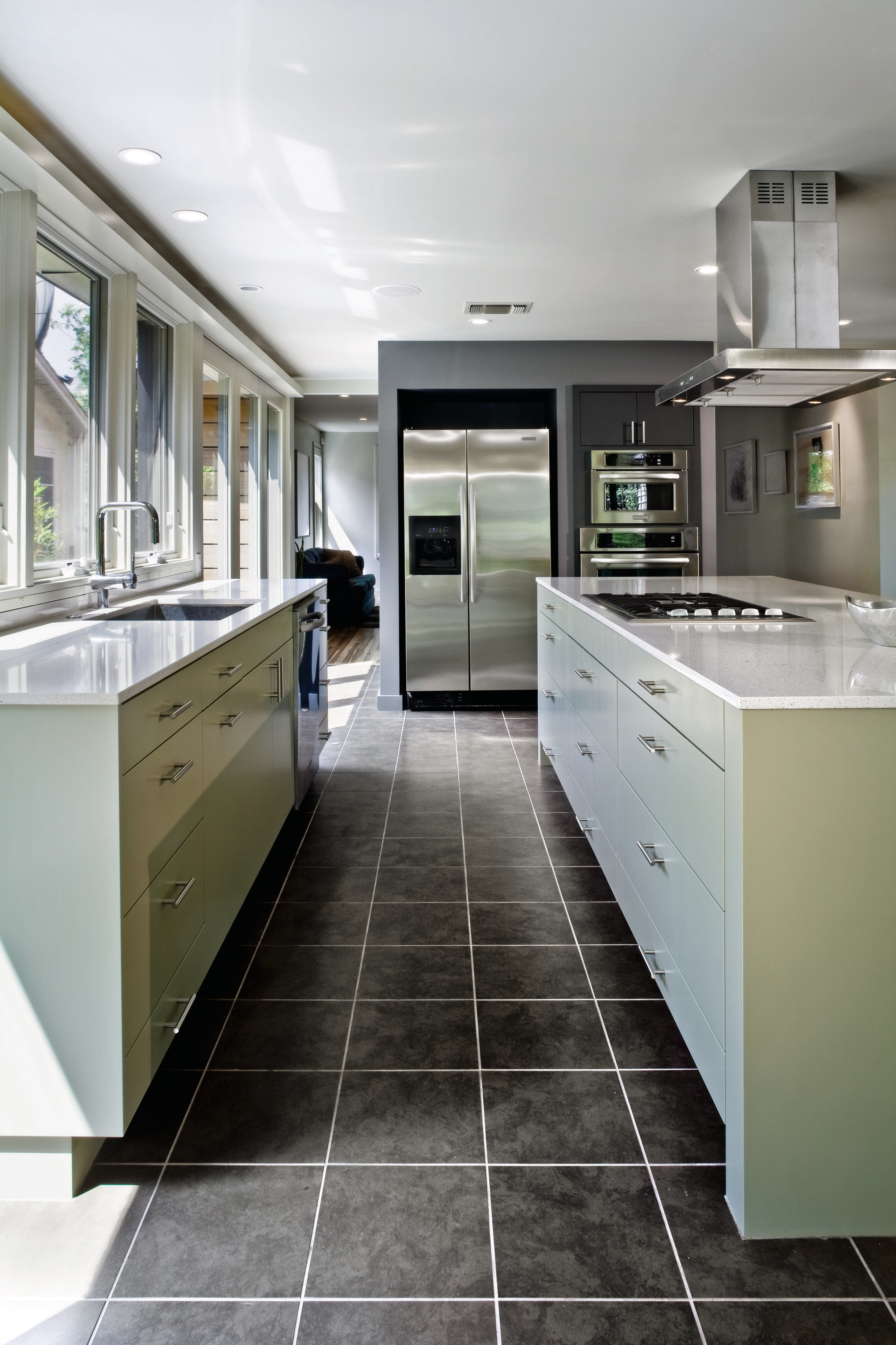 View of a kitchen which features a large cabinetry, countertop, cuisine classique, floor, home appliance, interior design, kitchen, gray